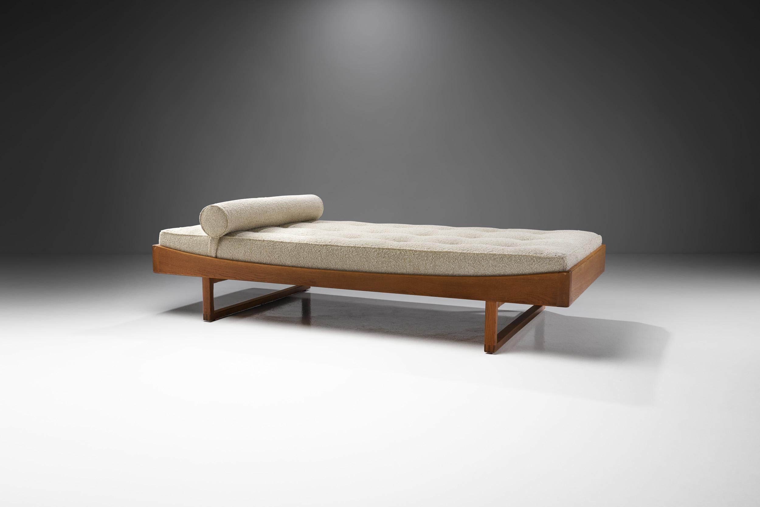 This gorgeous oak daybed model by the Danish furniture maker Bernhard Pedersen og Søn was inspired by classic Danish furniture design and simplicity.

The streamlined solid wood frame features a curvy top and geometric, so-called runner legs. From