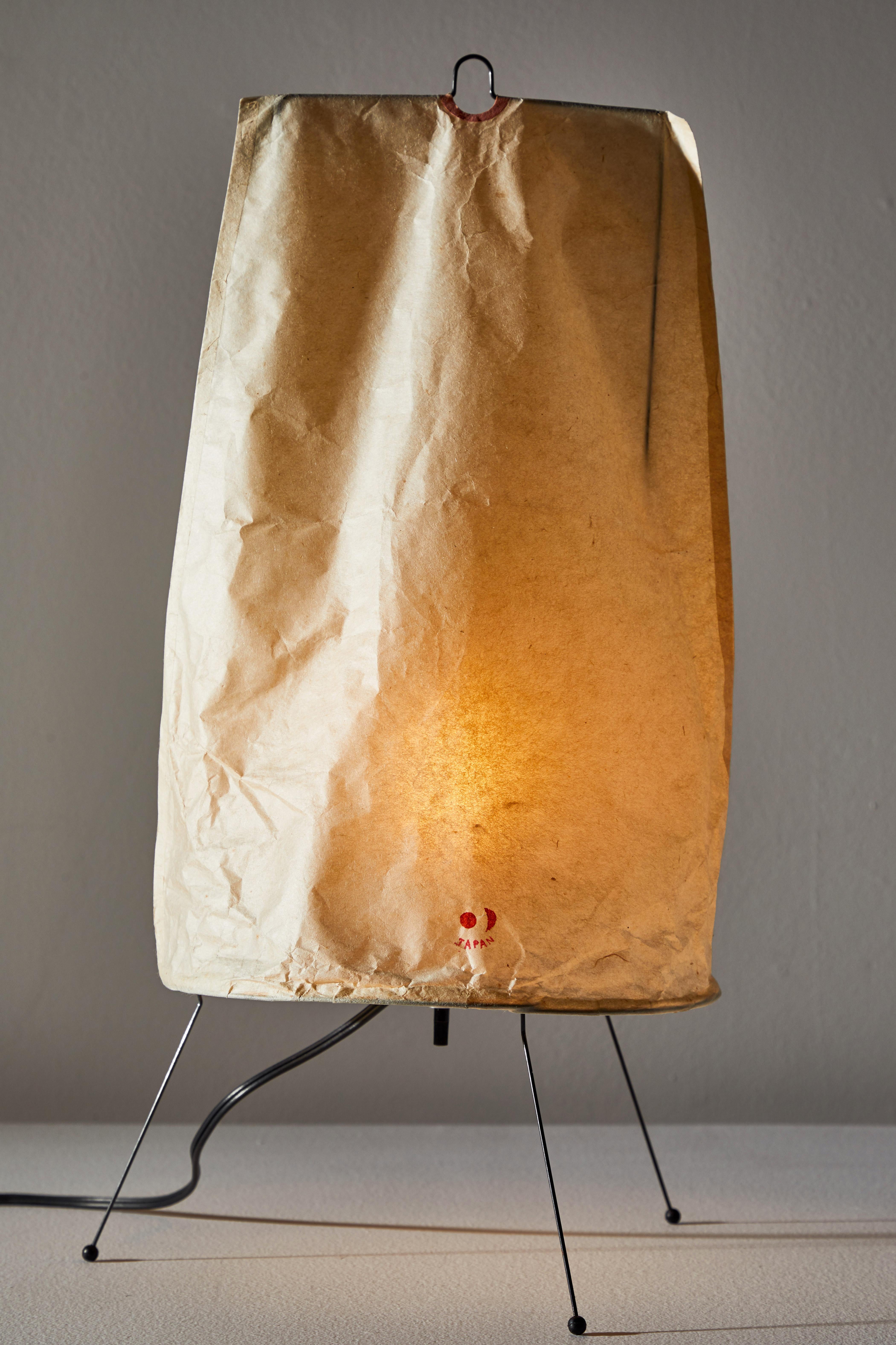 Lampe de table modèle 1P par Isamu Noguchi pour Akari. Conçu et fabriqué au Japon vers les années 1950 Fer:: papier de riz. Timbre original du soleil et de la lune. Accepte une ampoule E26 60w maximum de type candélabre. Les ampoules sont fournies