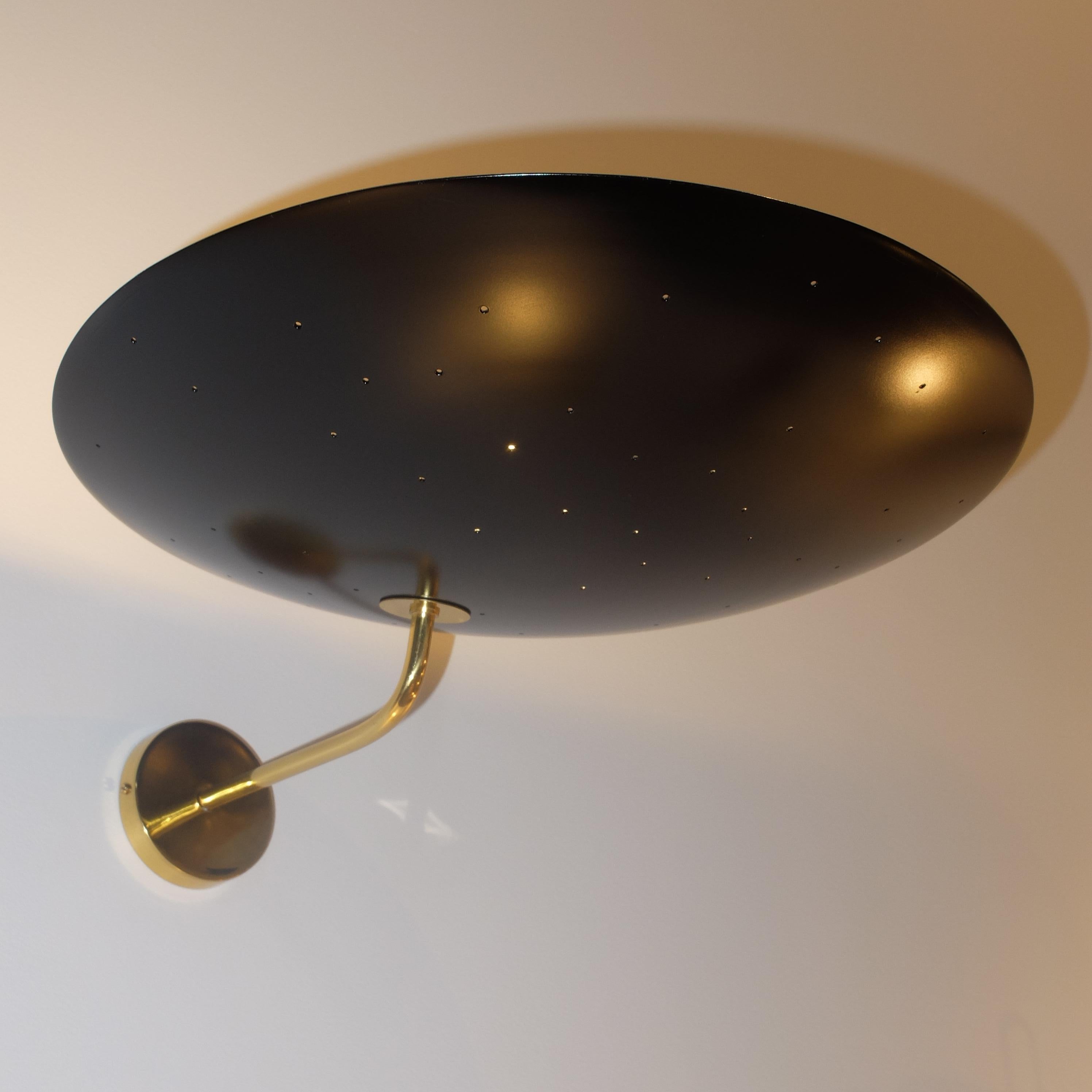 Au milieu des années 1950, Pierre Disderot conçoit une élégante applique dans l'esprit de sa lampe de table 1013 ; la pointe d'une sphère se fixe au mur par une fine agrafe et projette la lumière vers le plafond pour créer un éclairage d'ambiance