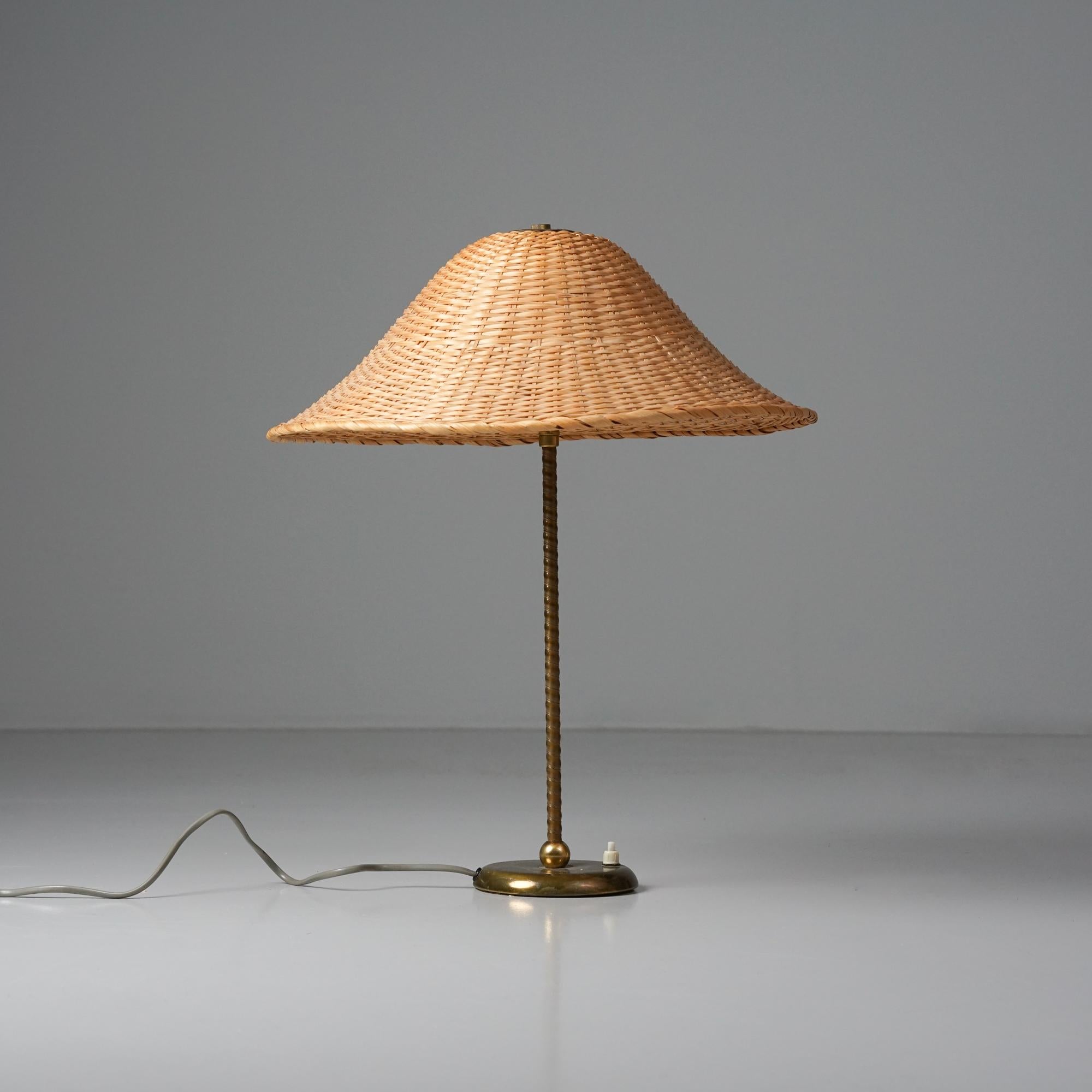 Lámpara de sobremesa Model 2059, diseño de Lisa Johansson-Pape, fabricada por Orno Oy, década de 1950. Estructura de latón, envoltura de plástico y pantalla de ratán. Marcado. Buen estado vintage, pátina menor acorde con la edad y el uso. 

Lisa