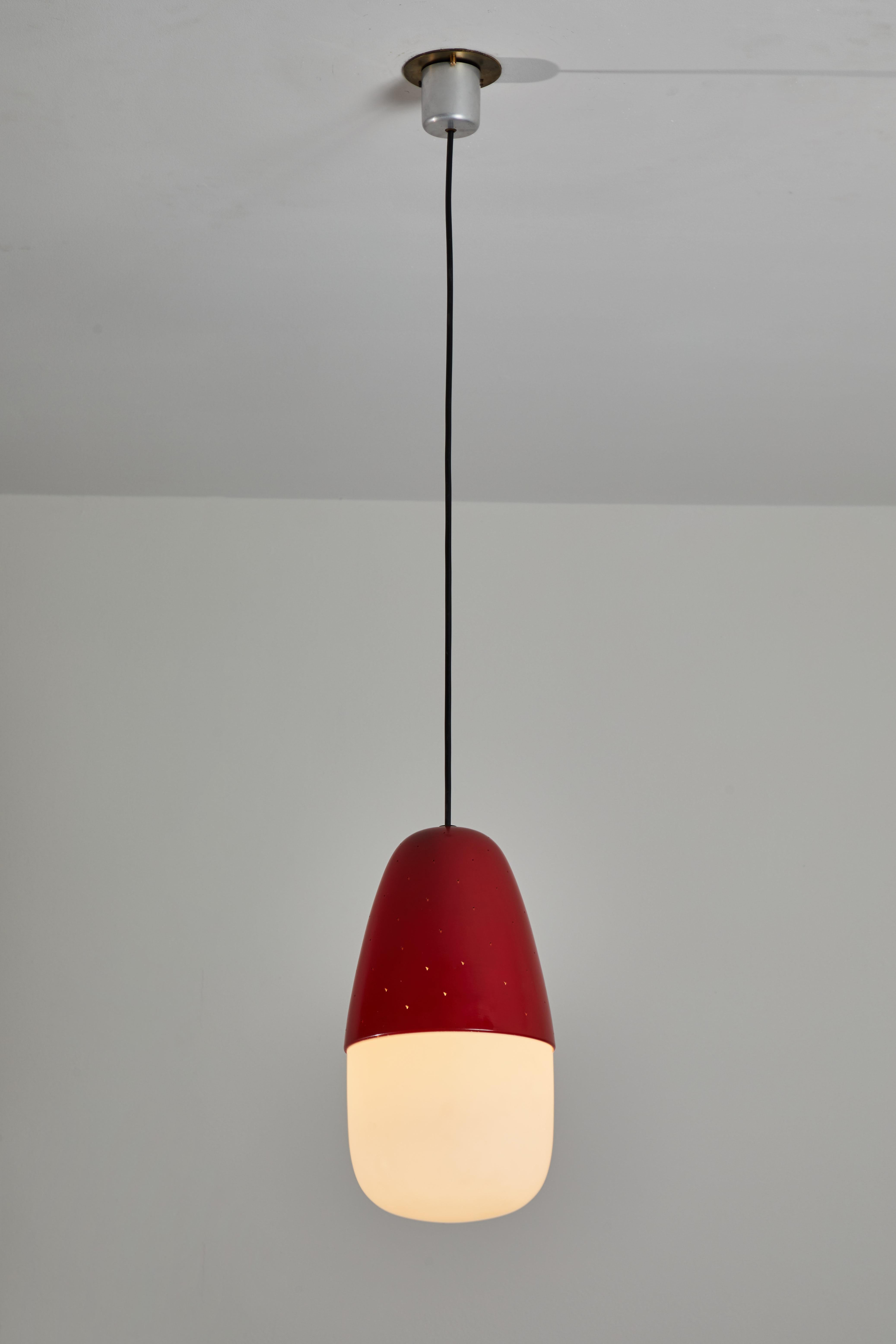 Model 2079 pendant by Gino Sarfatti for Arteluce. Designed and manufactured in Italy, 1955. Opaline glass diffuser, reflector with reversed micro perforated aluminum cup. Lacquered in red. Original canopy with custom brass ceiling plate. Maintains