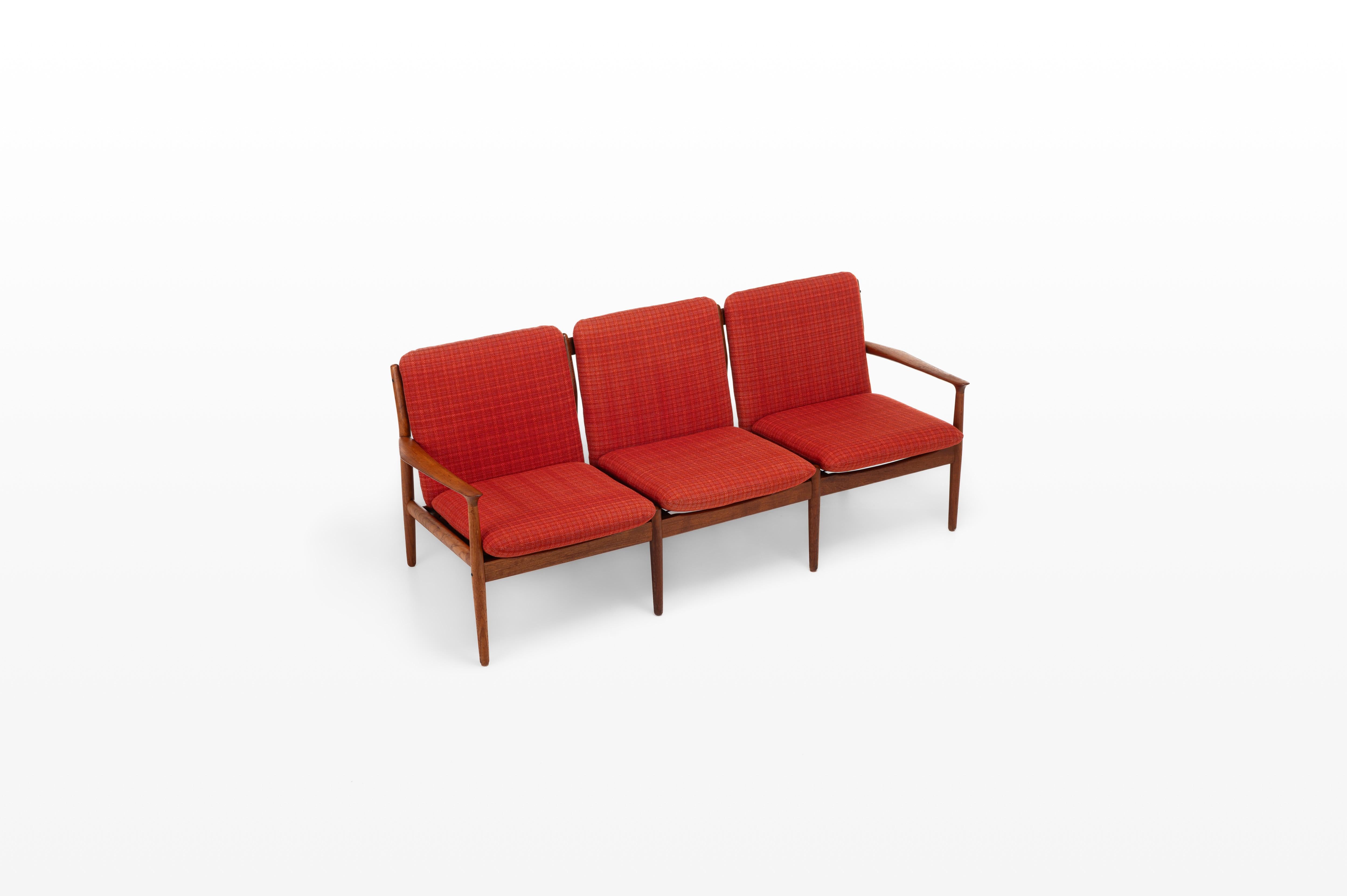 Schönes Sofa, entworfen von Grete Jalk für die Glostrup Mobelfabrik, hergestellt in Dänemark in den 1960er Jahren. Das Sofa trägt den Namen 'Modell 218', hat einen Rahmen aus Teakholz und den originalen rot karierten Stoff. Das Sofa ist in sehr