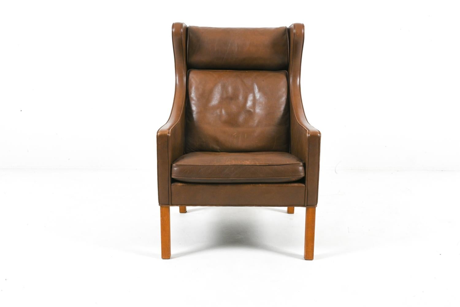 Immerse yourself in luxury and heritage with this stunning Model #2204 wingback armchair by Danish design legend Børge Mogensen for Fredericia. Crafted in the 1980s, this piece exemplifies Mogensen's signature approach to furniture design, which