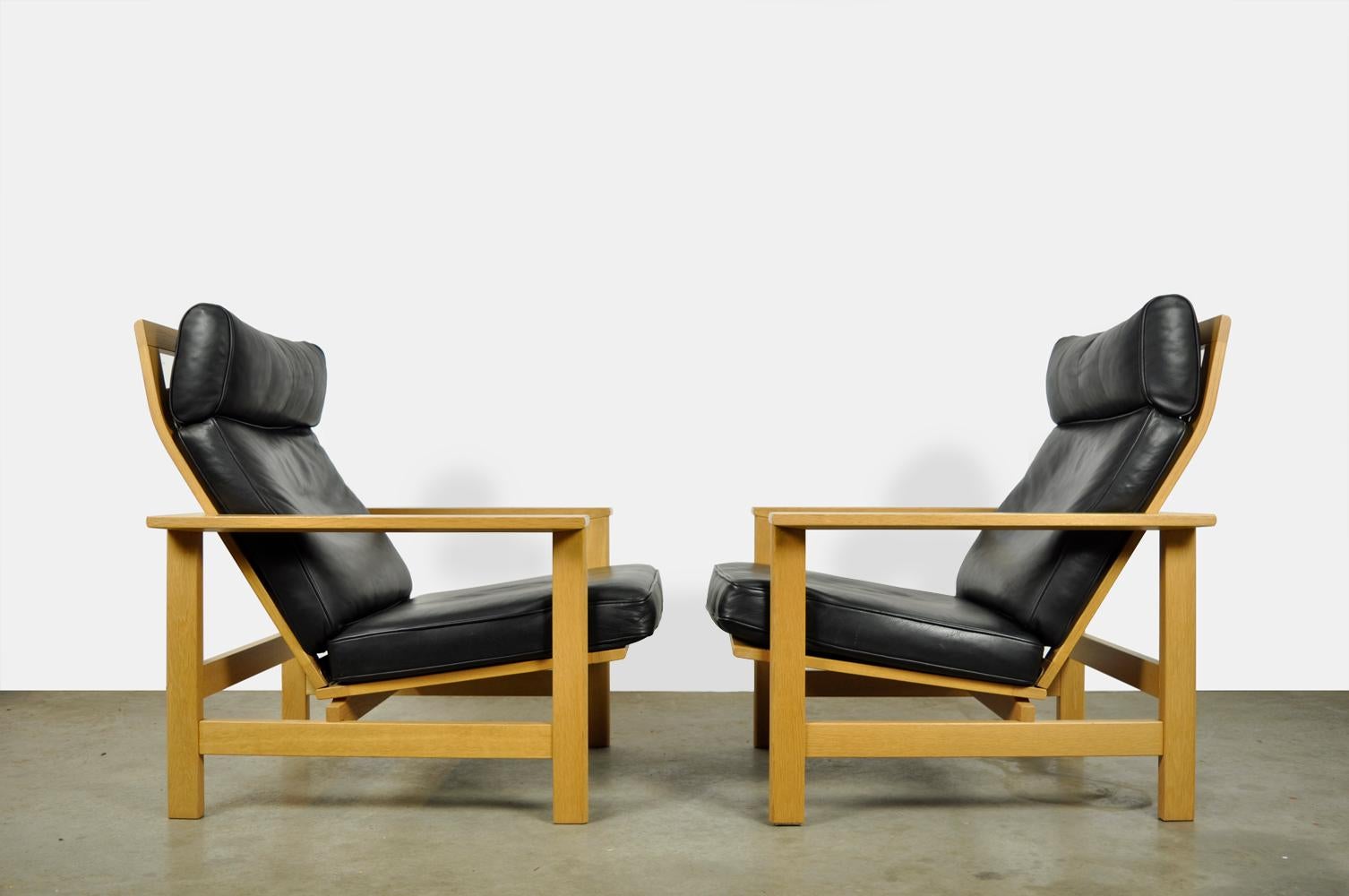 Scandinavian lounge armchairs, model 2461, designed by Soren Holst and produced by Frederica, 1970s Denmark. The lounge armchairs have a light oak frame with a backrest that can be adjusted in two positions. There are black leather cushions in the