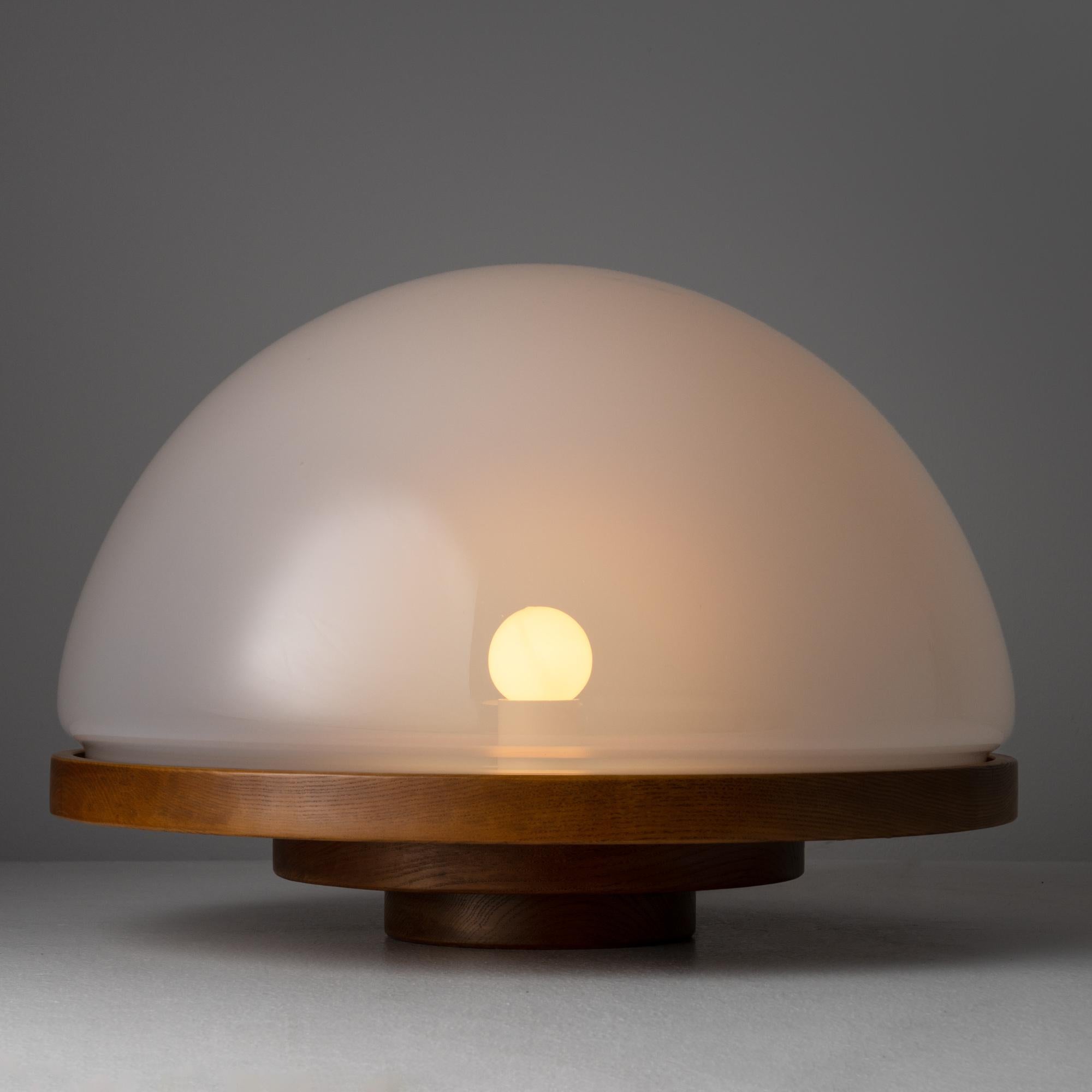 Model 3/3 Selenova table lamp by Luigi Massoni. Designed and manufactured in Italy circa the 1970s. This lamp is a simple yet sophisticated design with a tiered hardwood cylindrical base, holding a beautiful clear sandblasted piece of blown glass.