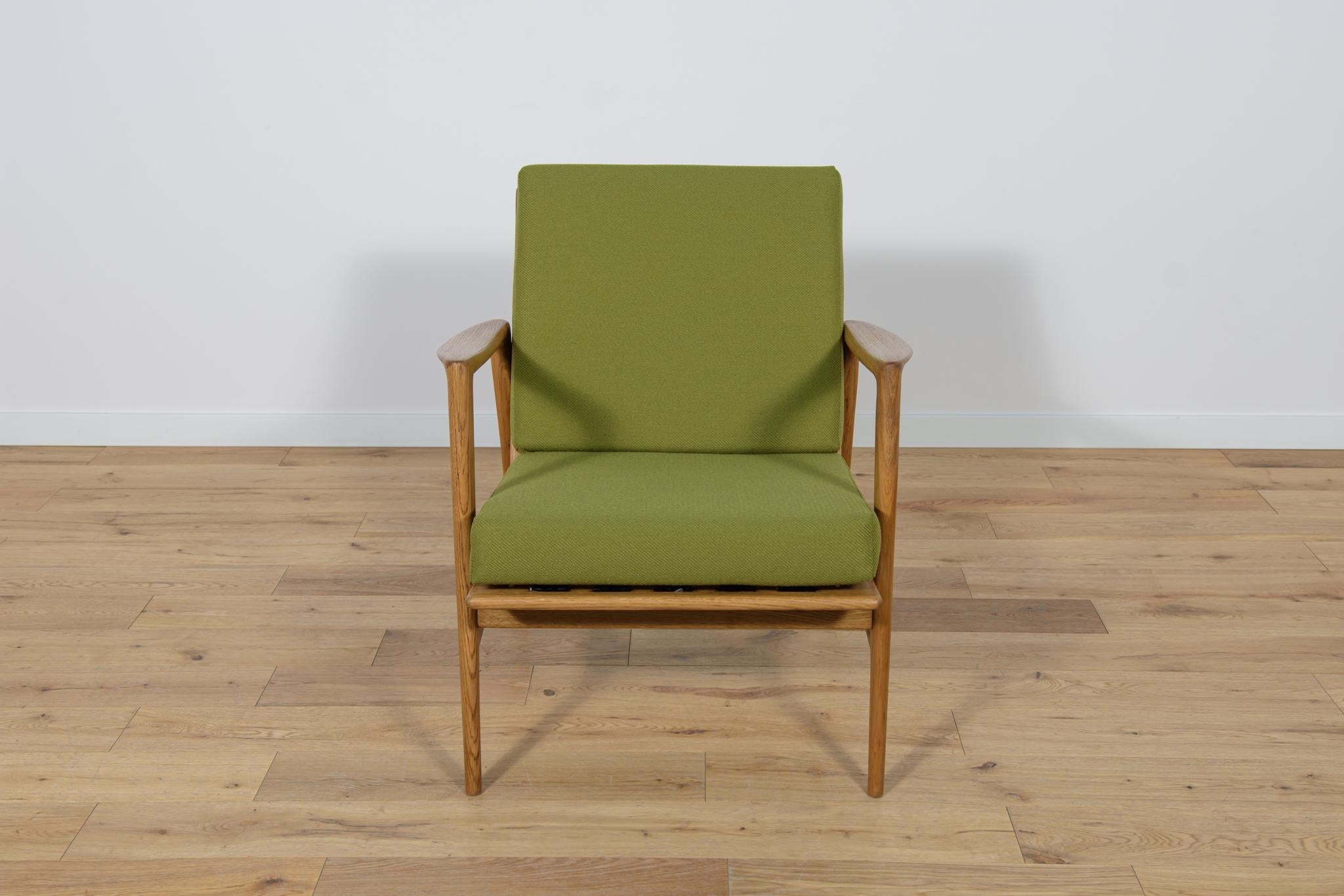 The armchair that was produced by the Polish company Swarzędzka Furniture Factory. Armchair have been professionally restored. The pillows were replaced with new ones, upholstered with high-quality green fabric. The wooden structure has been cleaned