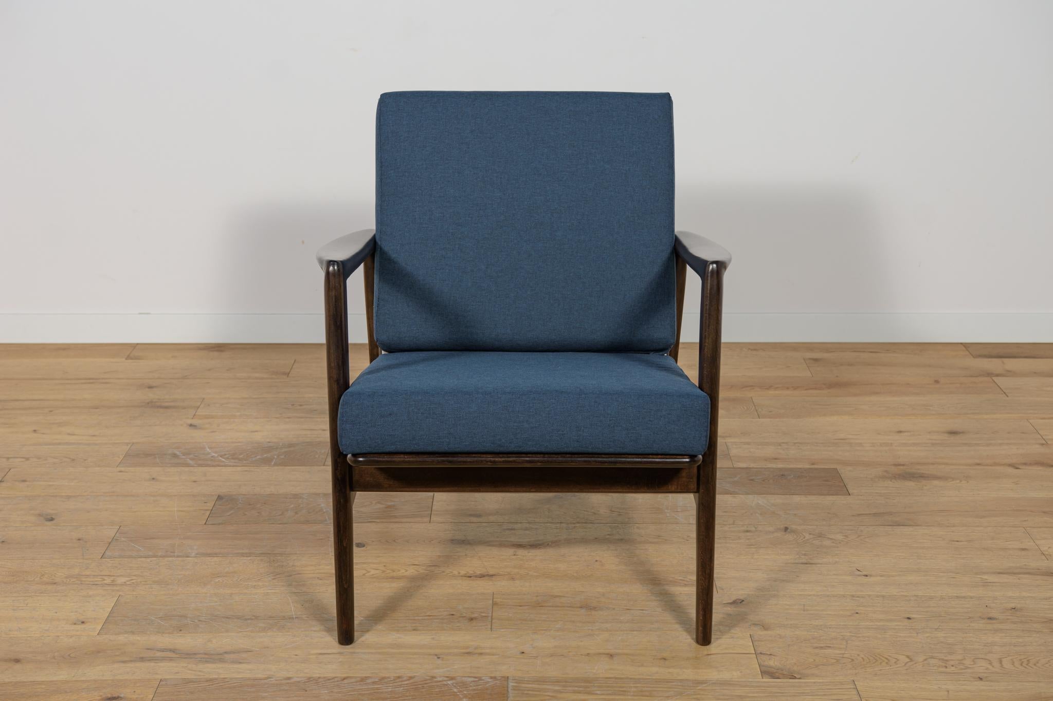 Questa poltrona è stata prodotta dall'azienda polacca Swarzędzka Furniture Factory negli anni '60. La poltrona è dotata di nuovi cuscini, rivestiti in un tessuto blu navy di qualità. Il telaio in faggio è stato ripulito dalla vecchia superficie,
