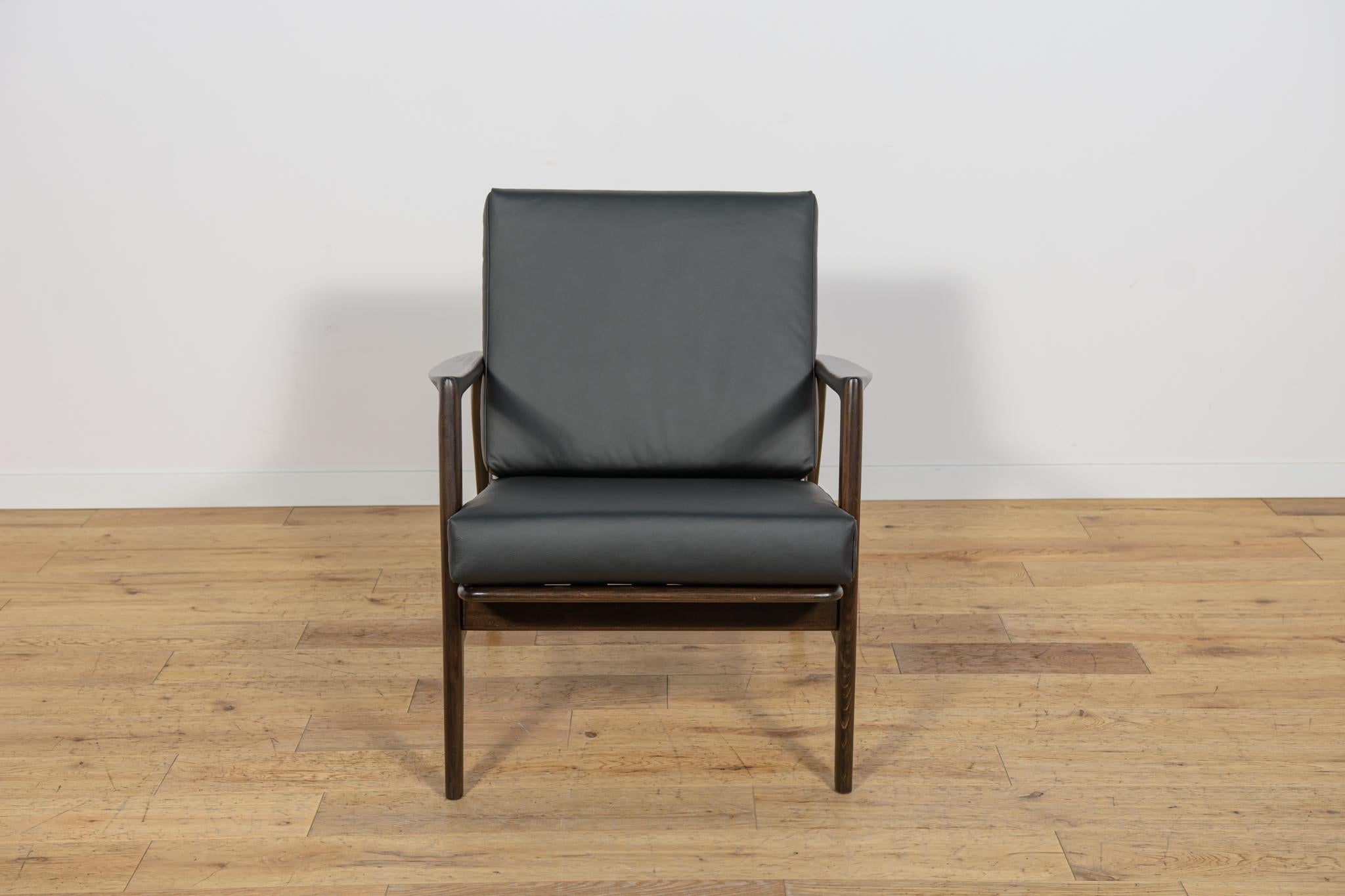 El sillón fue fabricado por la empresa polaca Swarzędzka Furniture Factory en los años 60. El sillón tiene cojines nuevos, retapizados en un cuero negro nuevo de calidad. El armazón de haya se ha limpiado de la superficie vieja, se ha pintado con un