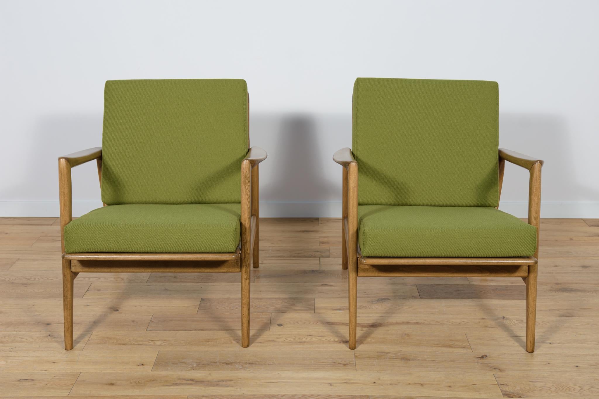 This pair of armchairs was produced by the Polish company Swarzędzka Furniture Factory in 60s.The armchairs have new cushions, reupholstered in a quality green fabric. The beech framehas been cleaned, painted with a walnut colored stain, and
