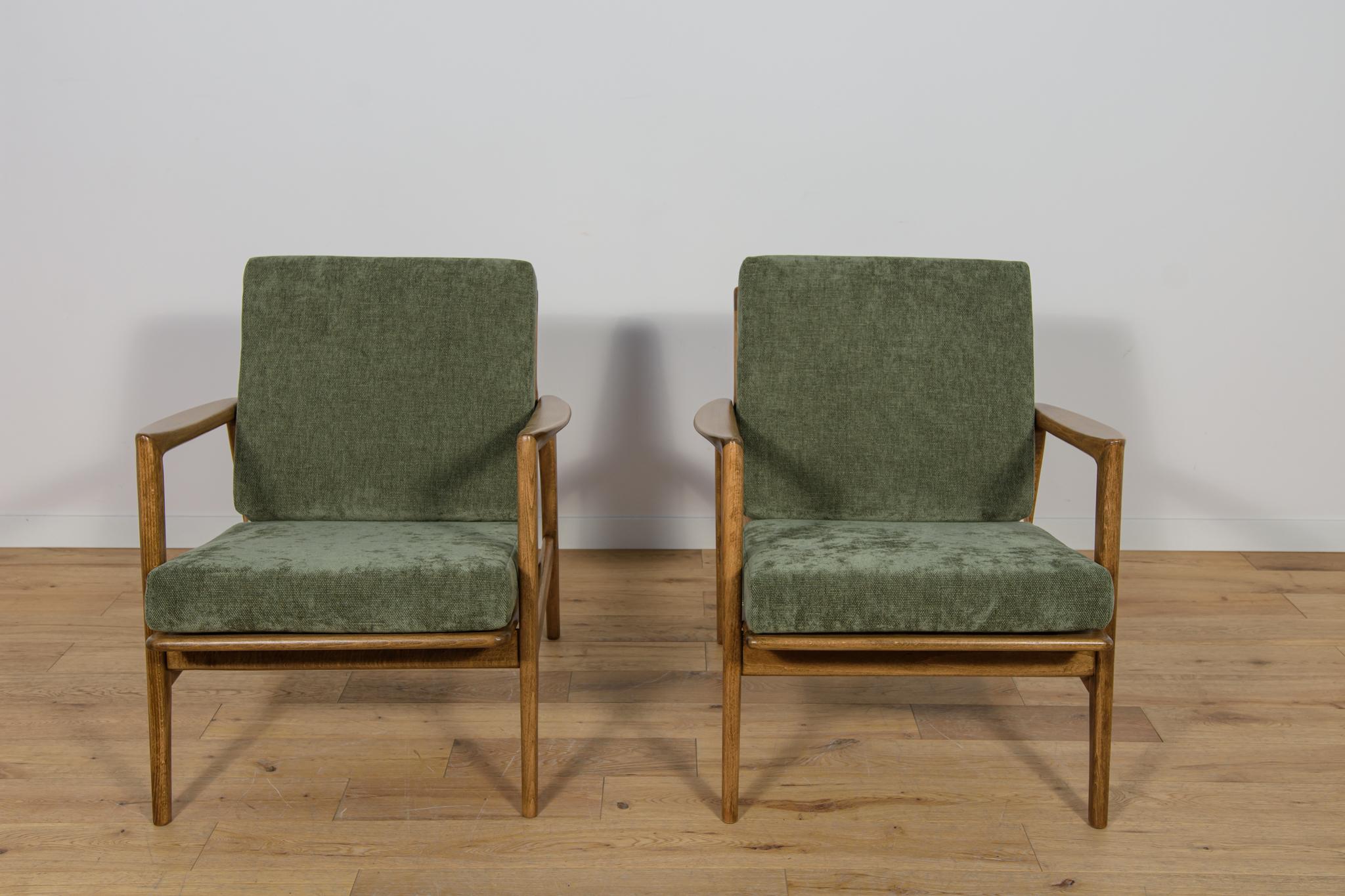 Cette paire de fauteuils a été produite par la société polonaise Swarzędzka Furniture Factory dans les années 60. Les fauteuils ont de nouveaux coussins, retapissés dans un tissu vert de qualité. Le cadre en hêtre a été nettoyé, peint avec une