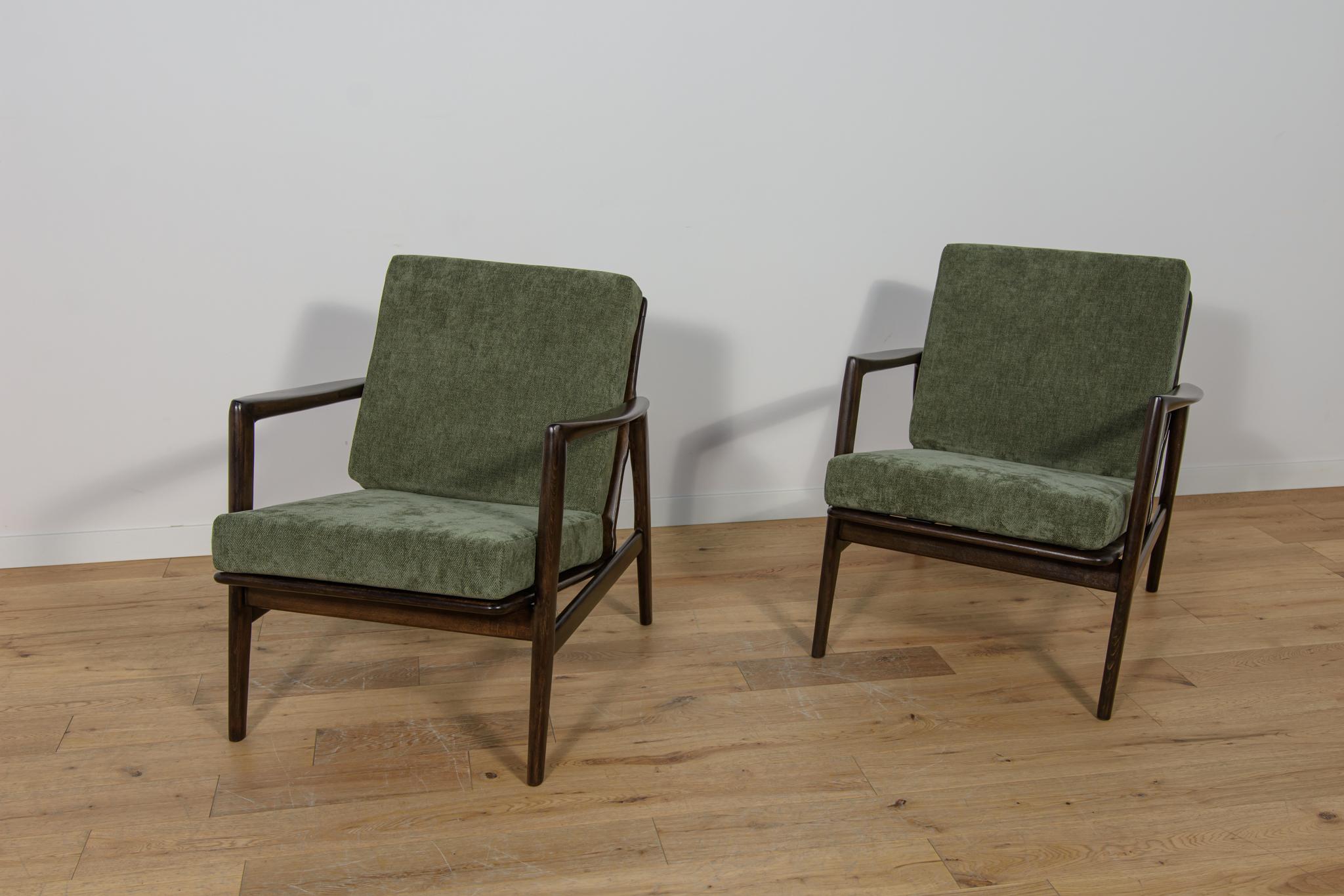 Questa coppia di poltrone è stata prodotta dall'azienda polacca Swarzędzka Furniture Factory negli anni '60. Le poltrone hanno nuovi cuscini, rivestiti in un tessuto verde di qualità. Il telaio in faggio è stato ripulito dalla vecchia superficie,