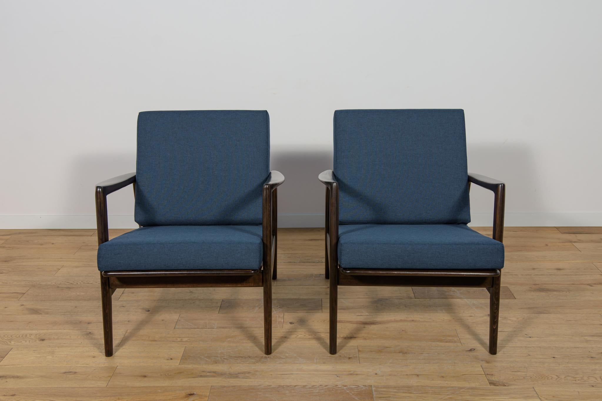 Questa coppia di poltrone è stata prodotta dall'azienda polacca Swarzędzka Furniture Factory negli anni '60. Le poltrone sono dotate di nuovi cuscini, rivestiti in un tessuto blu navy di qualità. Il telaio in faggio è stato ripulito dalla vecchia
