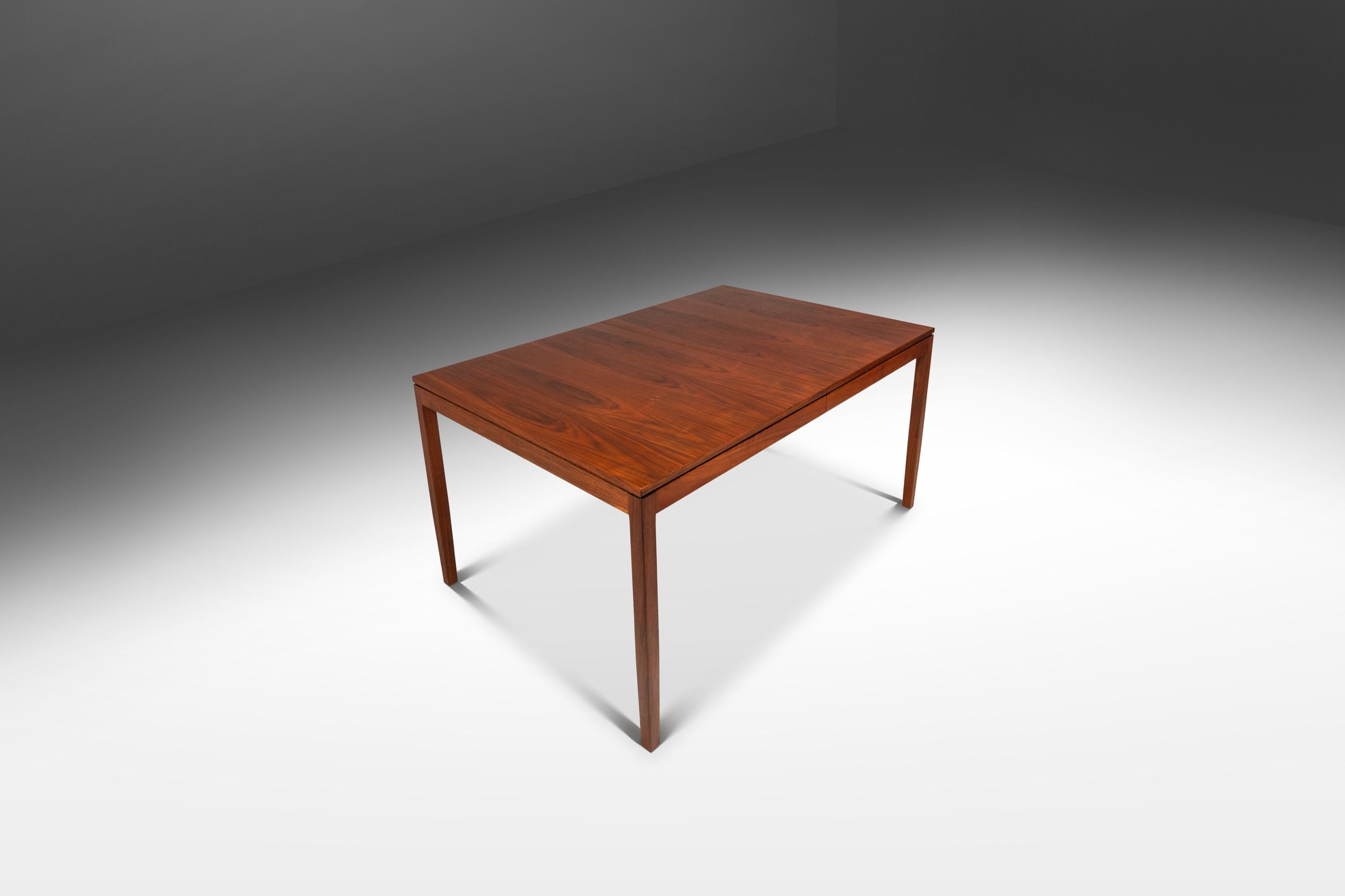 Dieser seltene Mid-Century-Esstisch aus Nussbaumholz, Modell 303, entworfen von Florence Knoll für Knoll Associates im Jahr 1957, ist ein Beispiel für den Höhepunkt des amerikanischen modernistischen Designs. Der Tisch ist aus reichem Nussbaumholz
