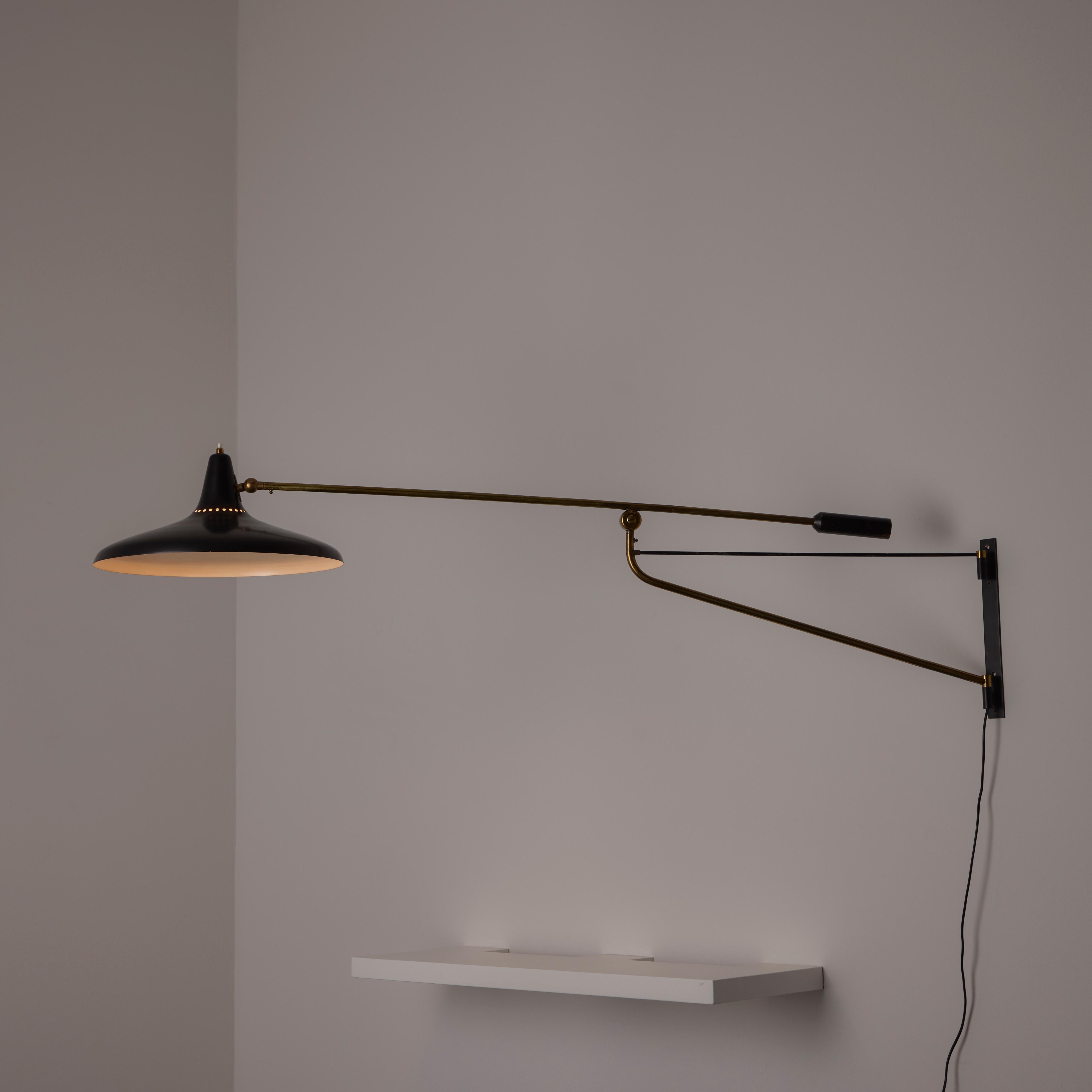 Model 3030 Wall Light by Stilnovo. Designed and manufactured in Italy, 1956. A jib style wall lamp with black enamel shade and brass details. The light holds a counter-balance weighted handle to swing the jib and the shade can be articulated to