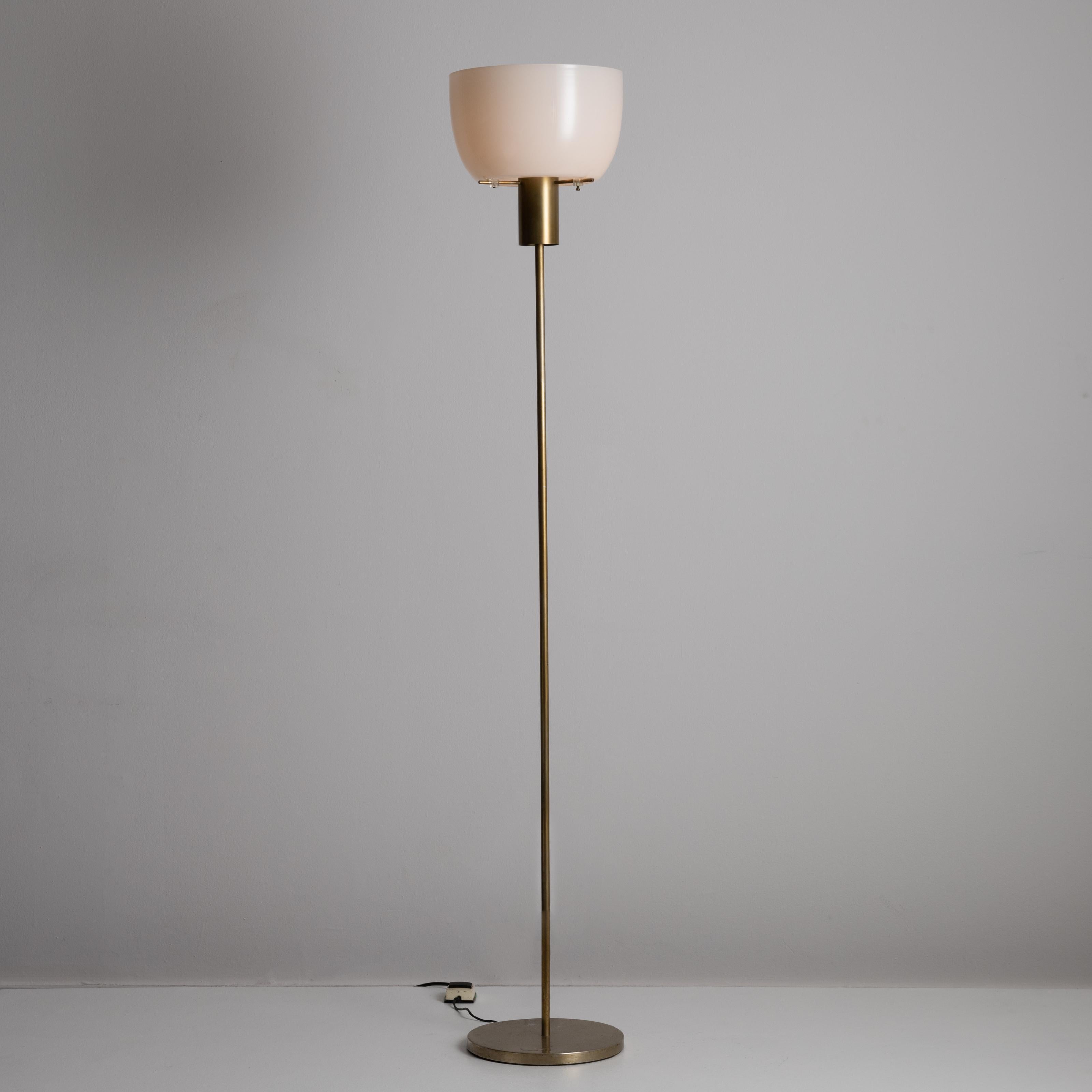 Model 3306 floor lamp by Ostuni & Forti for Oluce. Designed and manufactured in Italy, circa the 1960s. This model features a beautiful opaline glass shade, which sits directly onto a cross barred brass floor lamp stem. Though simplistic in nature,
