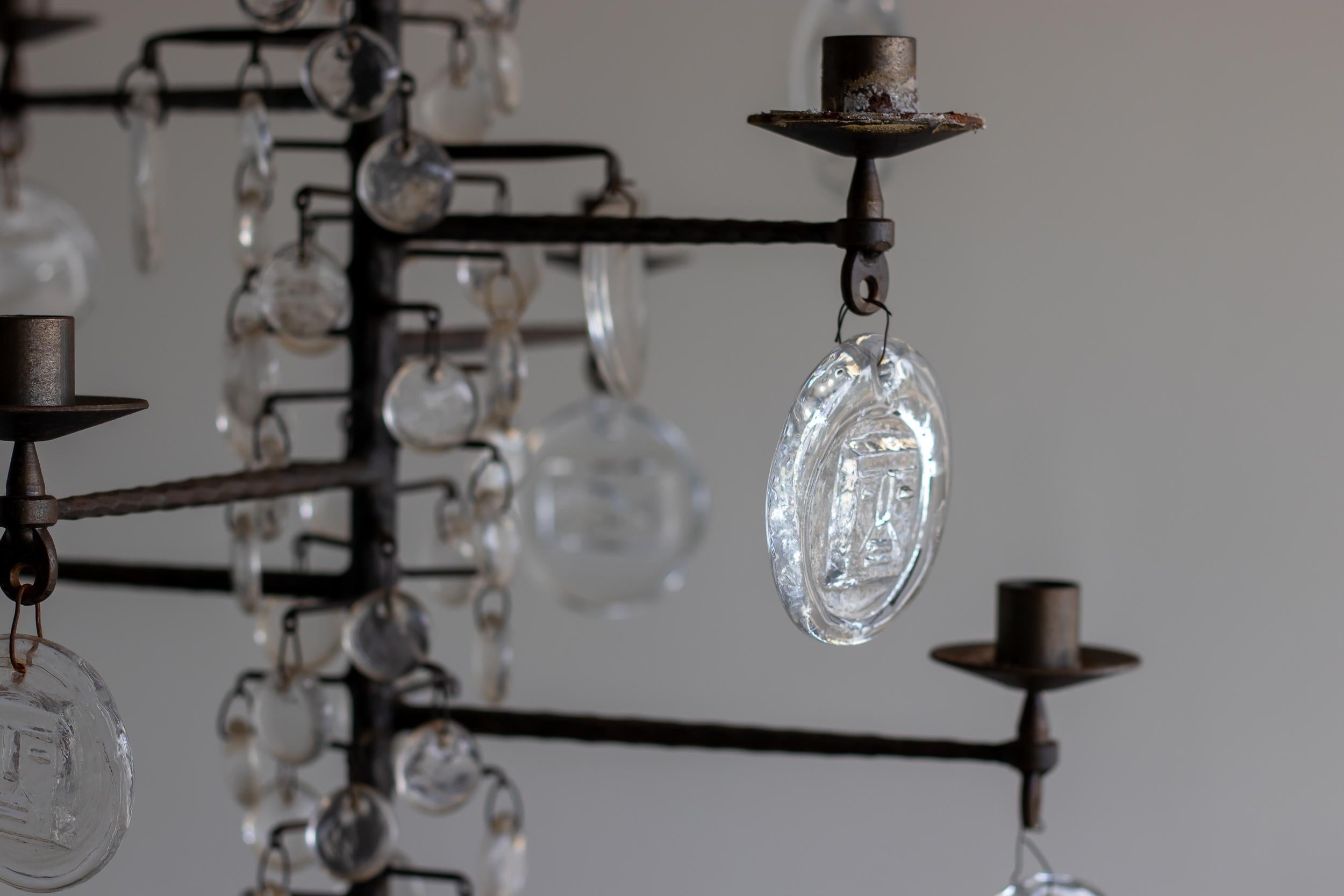 A vintage twelve-arm chandelier designed by Erik Hoglund, model 341.
Glass pendants made by Boda Nova Glassworks; wrought iron frame made by Axel Stromberg Ironworks, Sweden, circa 1957. Features a variety of glass pendants; larger pendants have