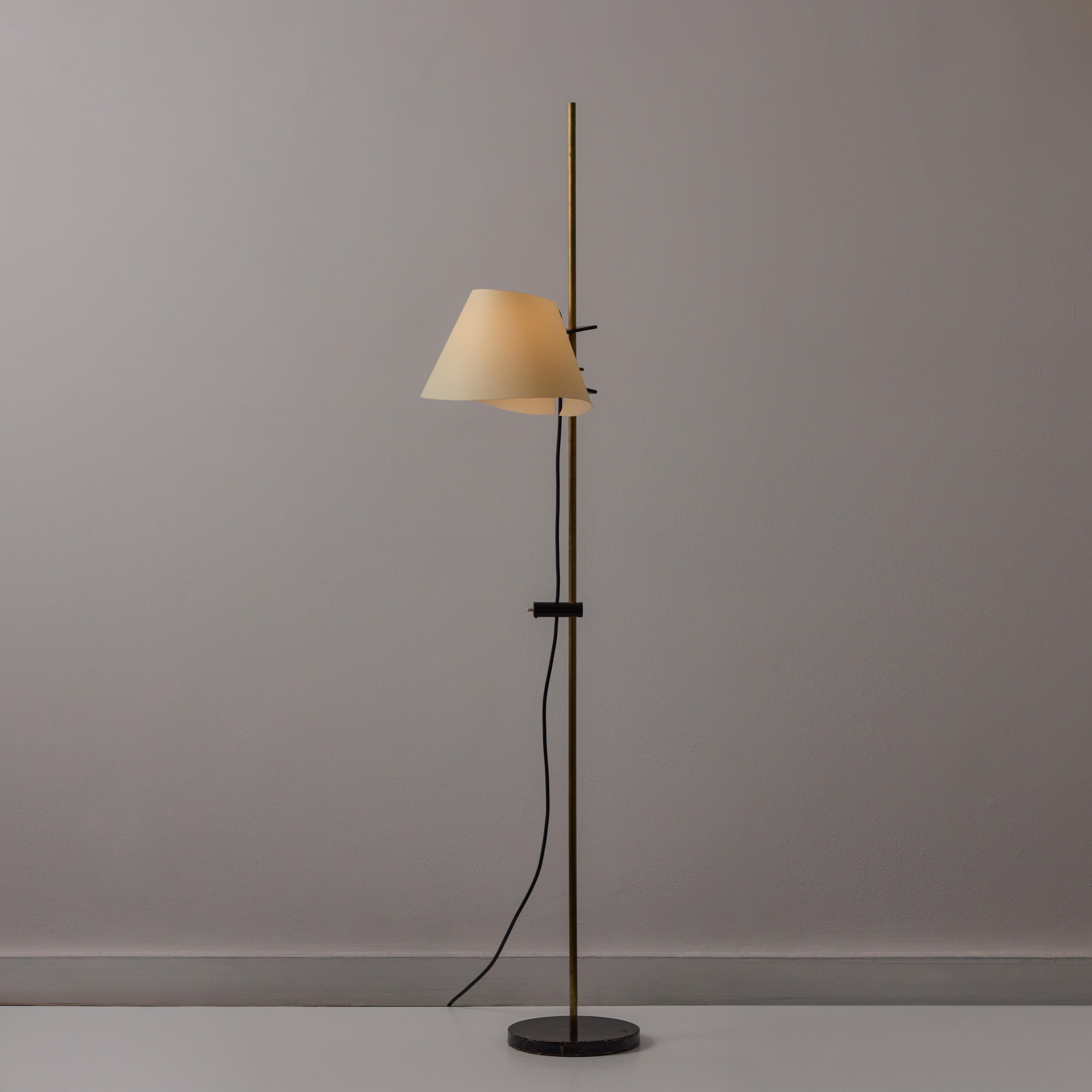 Lámpara de pie regulable Model 398 de Ostuni & Forti para Oluce. Diseñado y fabricado en Italia hacia 1959. Base de acero ennegrecido y vástago de latón. La pantalla de papel es regulable en altura. El interruptor de pedal de suelo está unido en