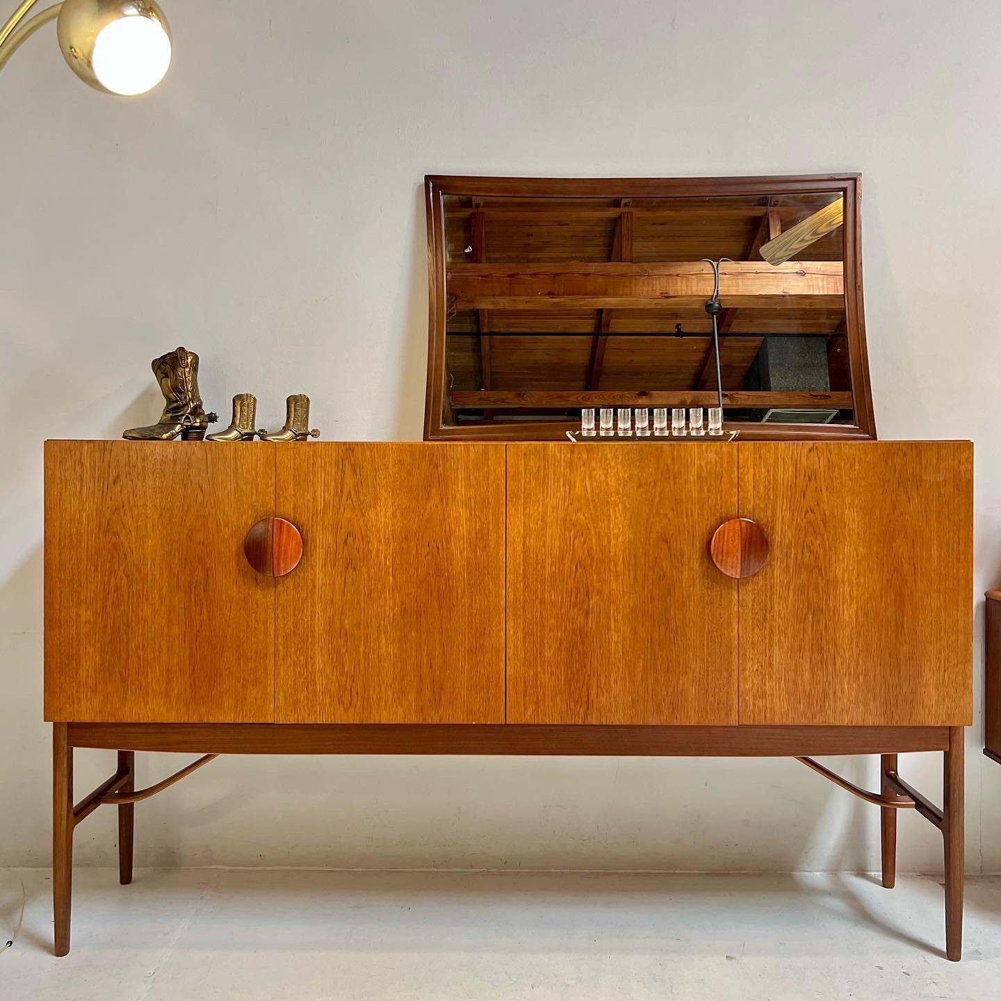 A beautiful Model 4060 high sideboard designed by Danish designer Ib Kofod Larsen for G-Plan, and finished in teak with solid Bombay rosewood handles and afromosia legs. Simple and distinctive lines with large split circular handles. This beautiful