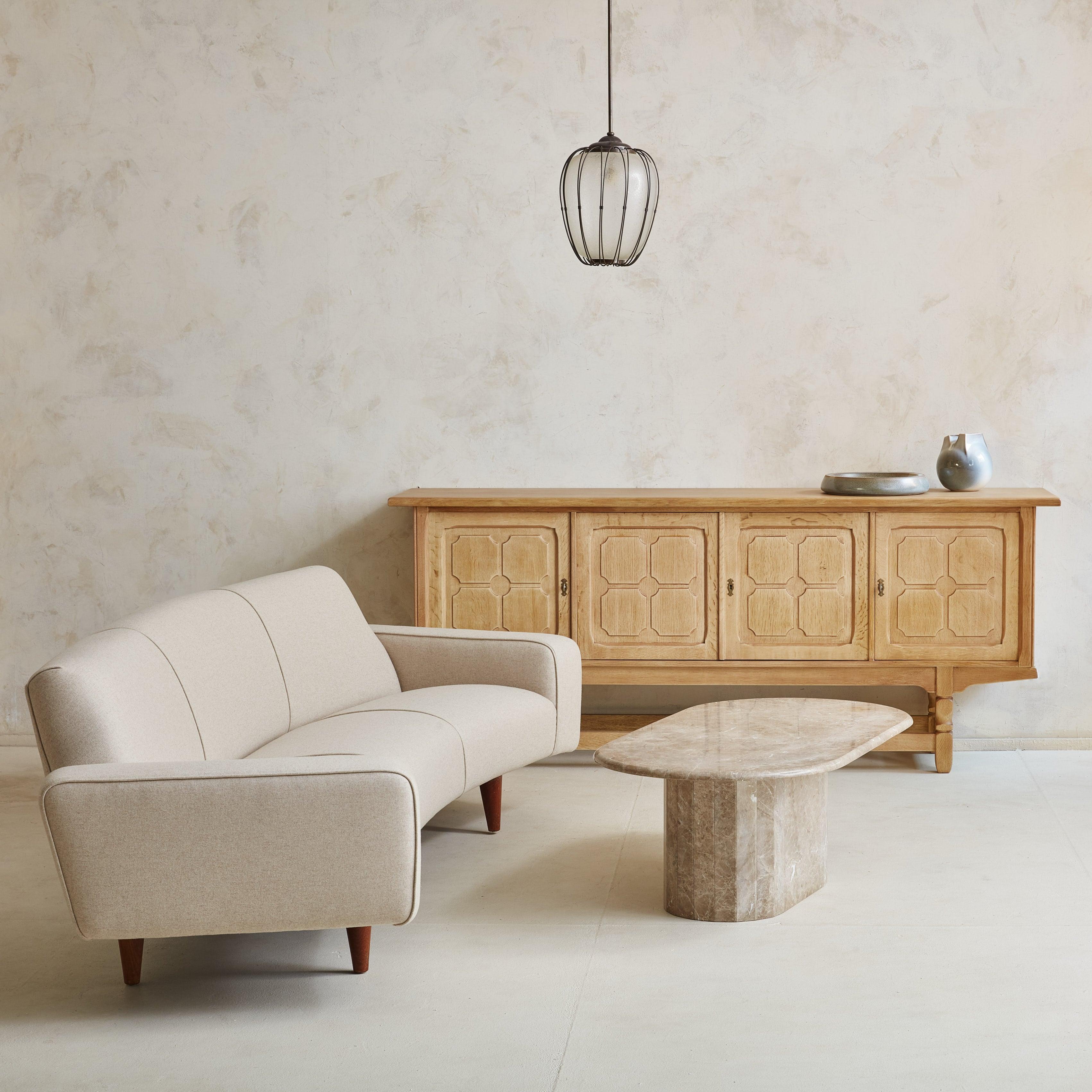 A rare ‘Model 450’ banana sofa designed by Illum Wikkelsø for Aarhus Polstermøbelfabrik in the 1960s. The striking, Danish Modern silhouette features a wide curved back, softened angular armrests, and decorative piping along the seams. This sofa