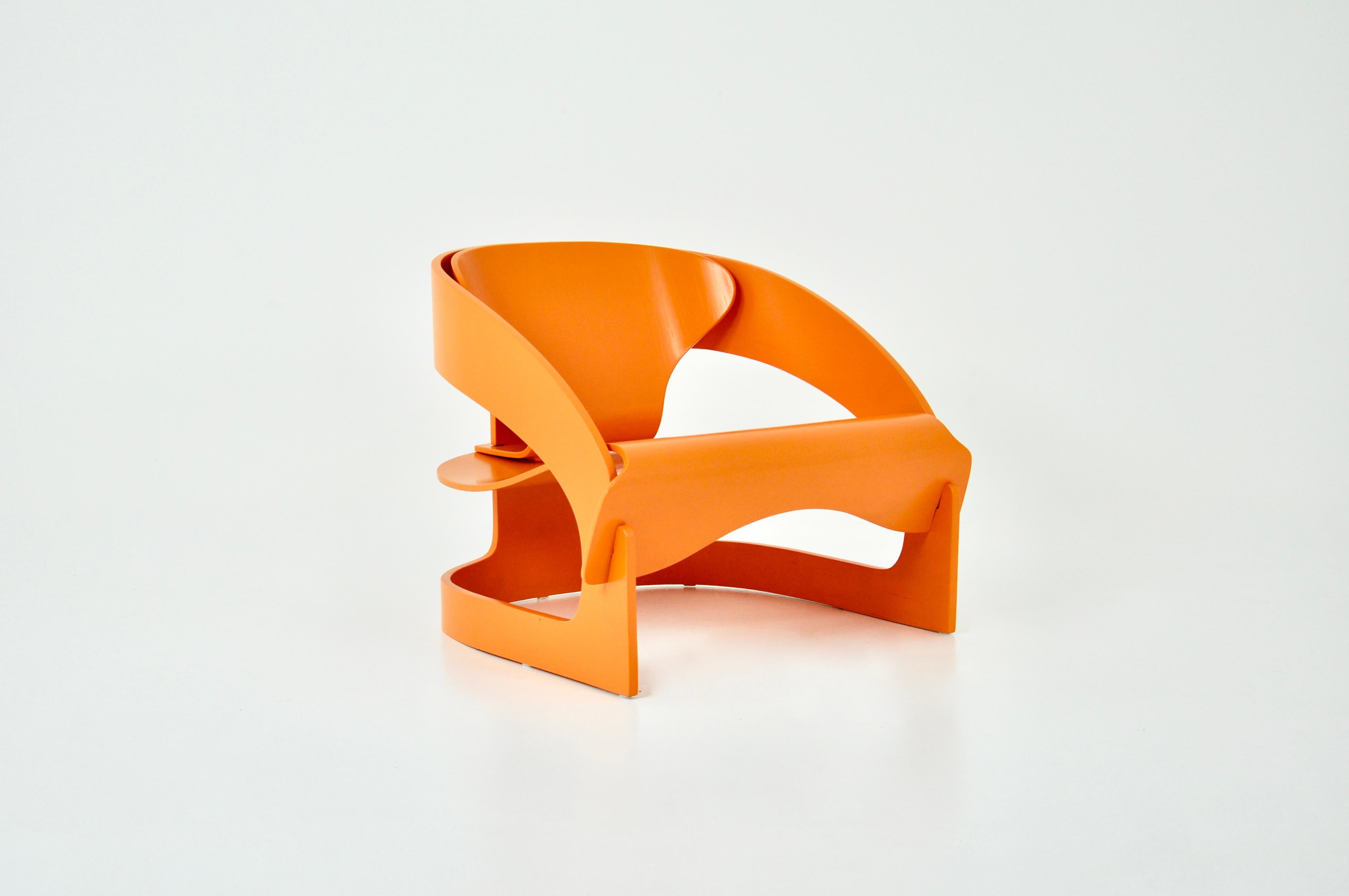Fauteuil en bois orange de Joe Colombo. Le fauteuil est numéroté. Dimensions : Hauteur d'assise 34cm Usures dues au temps et à l'ancienneté du fauteuil.