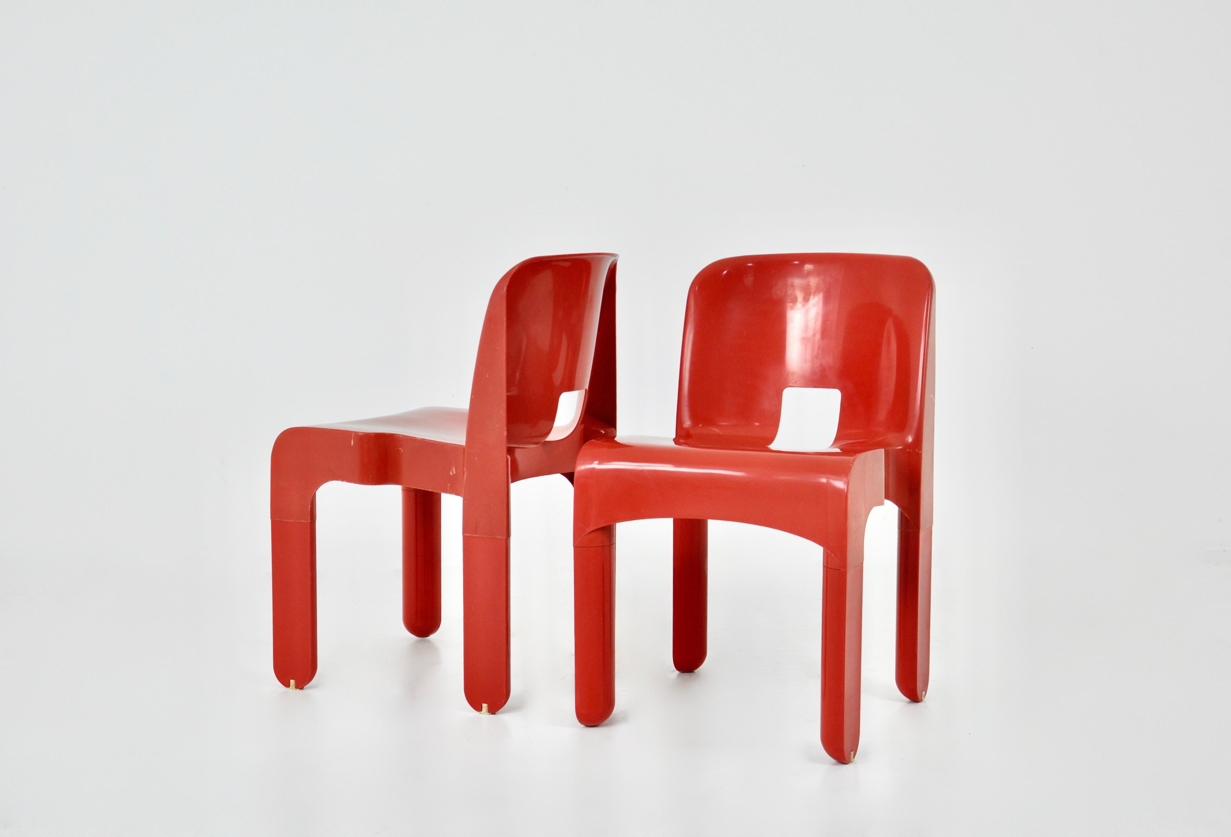 Red chairs by Joe Colombo. Model 4867. Stamped below the chairs. Wear due to time and the age of the chairs.
