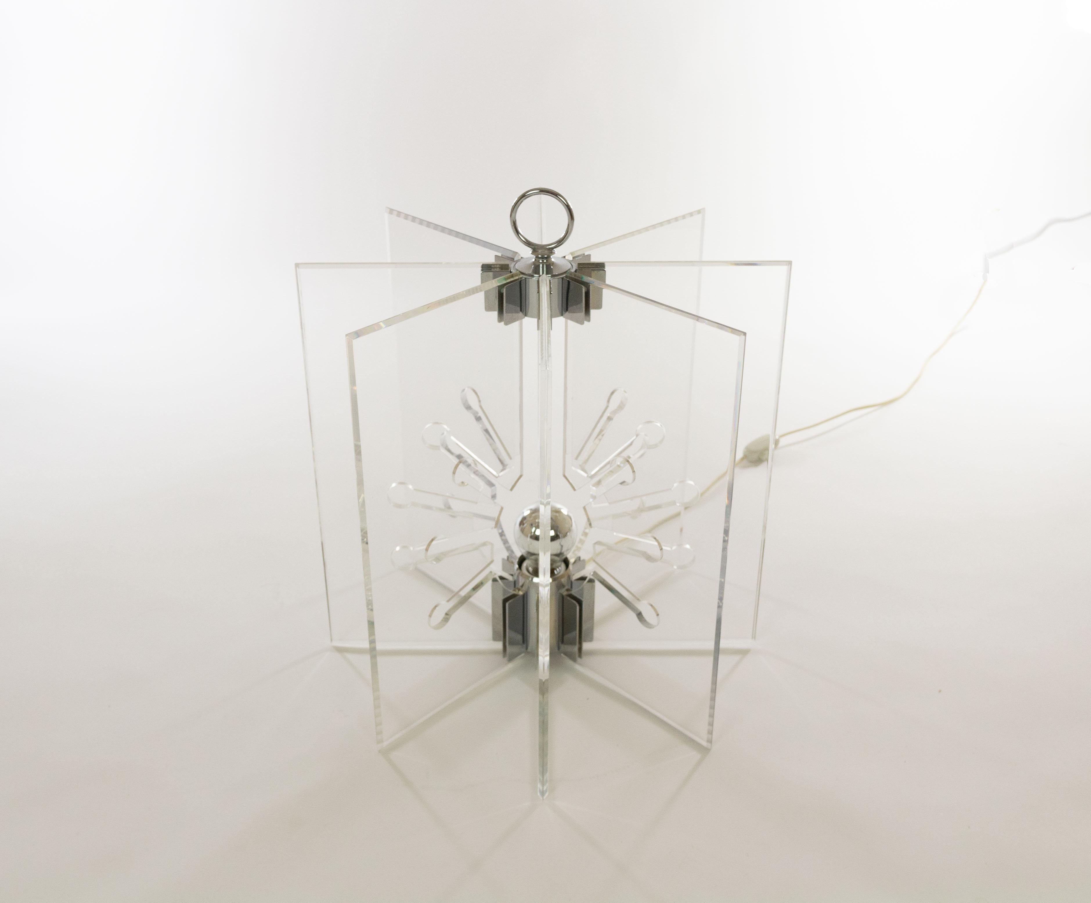 Lampe de table modèle 524 conçue par Franco Albini et Franca Helg et fabriquée par Arteluce.

La maquette se compose de huit panneaux rectangulaires en Perspex transparent placés en forme d'étoile. Les panneaux de Perspex sont maintenus ensemble