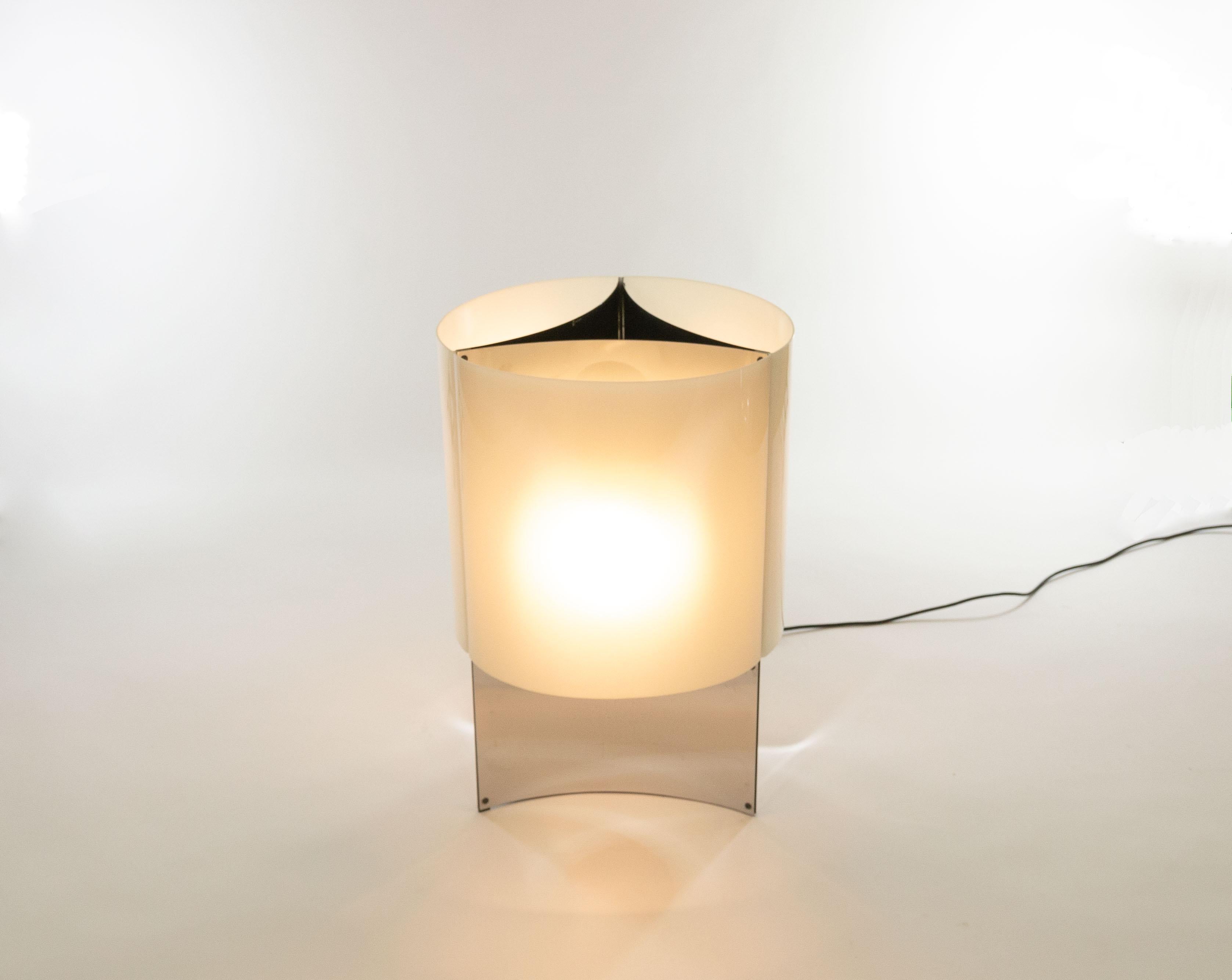 This elegant lamp model 526/G was designed in 1965 by Massimo Vignelli for Italian lighting manufacturer Arteluce.

Model 526/G is a table or floor lamp with a base that consists of three concave chromed sheets. This base is covered by white