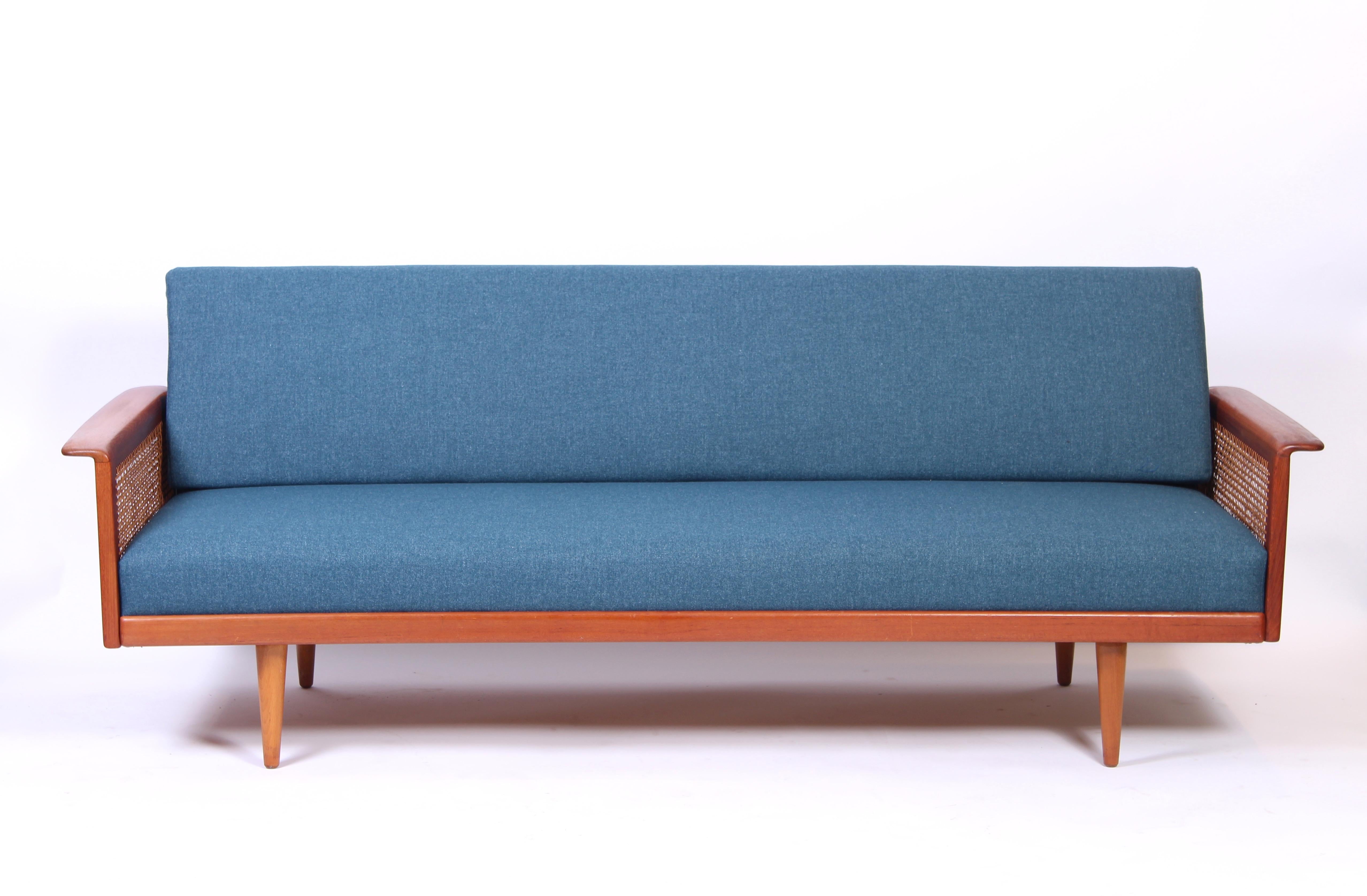 A midcentury Norwegian sofa designed by Knut Sæter for Vatne Møbler in the early 1960s. The sofa has a beech frame with teak and rattan armrests. The cushions has springs for a very hig comfort. New foam in the cushions and reupholstered in a high
