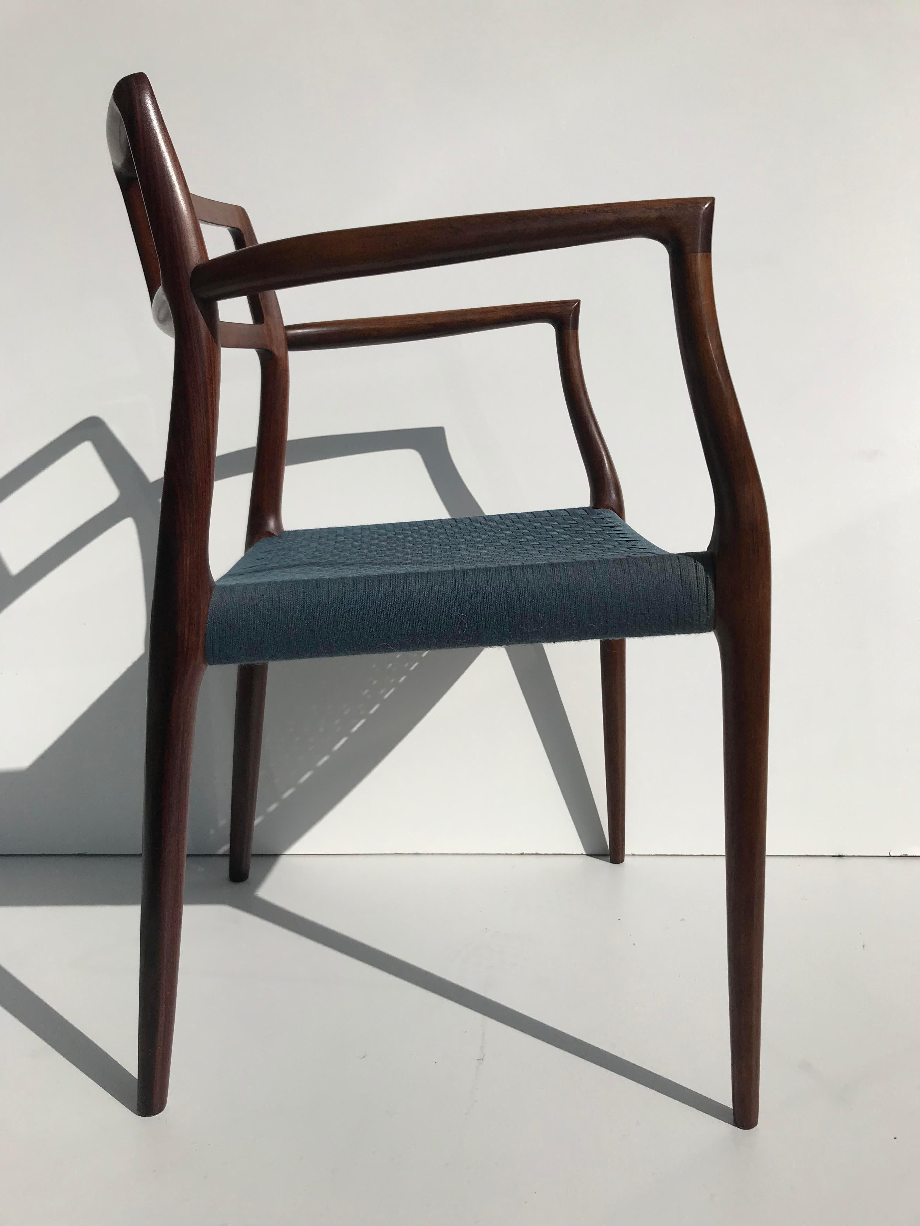 Model 64 armchair designed by Niels Moller. This example features rare, original, blue cording, in excellent condition. The finish is also original, and in very fine condition. Marked with Danish control button as well as J.L. Mollers Mobelfabrik