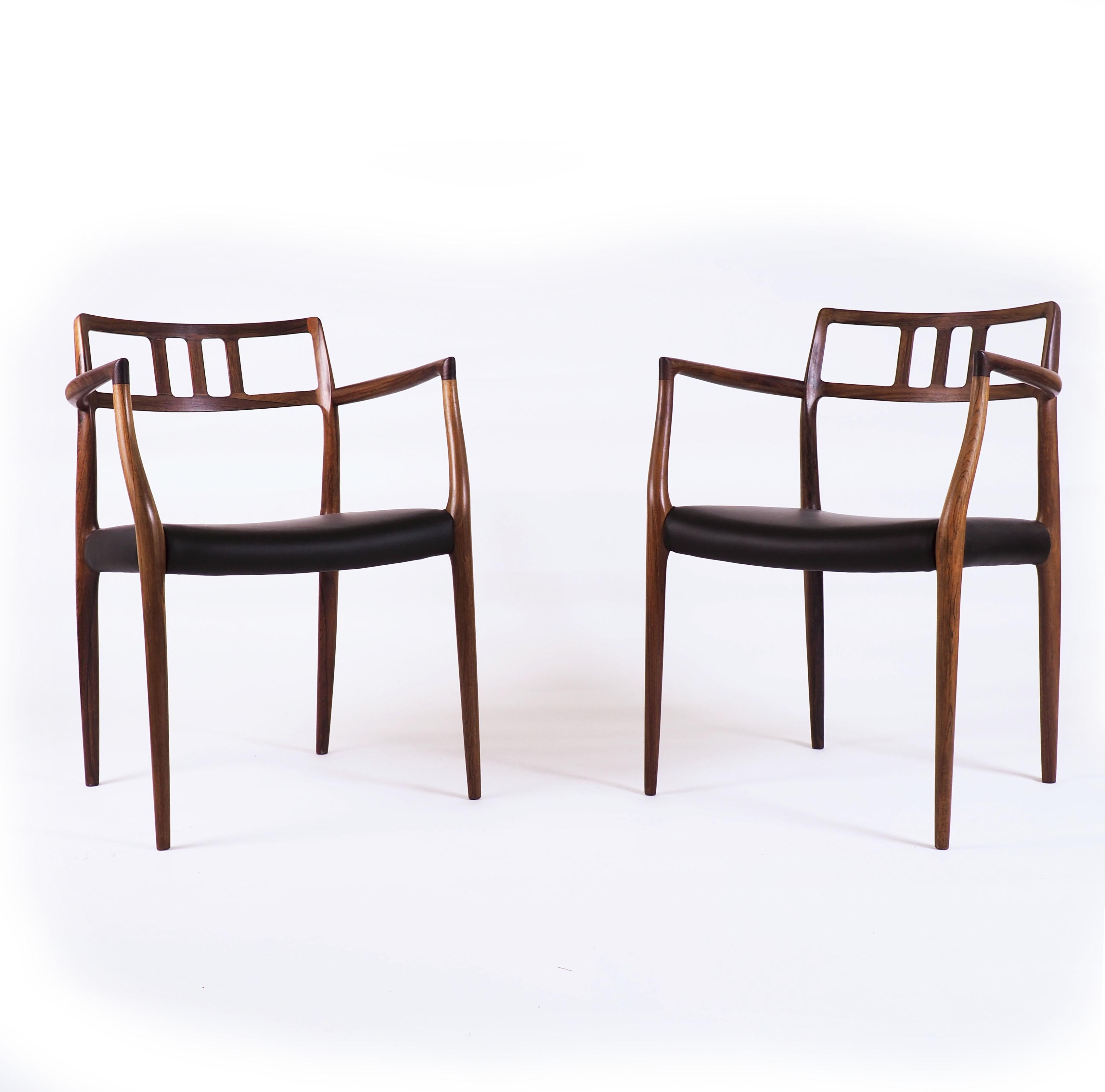 These two elegant armchairs by Niels O. Møller were made by the Danish high quality furniture make J.L.Møller. The model was numbered 64. This pair is made in solid rosewood and has got black leather seats.
The quality of the craftmanship is