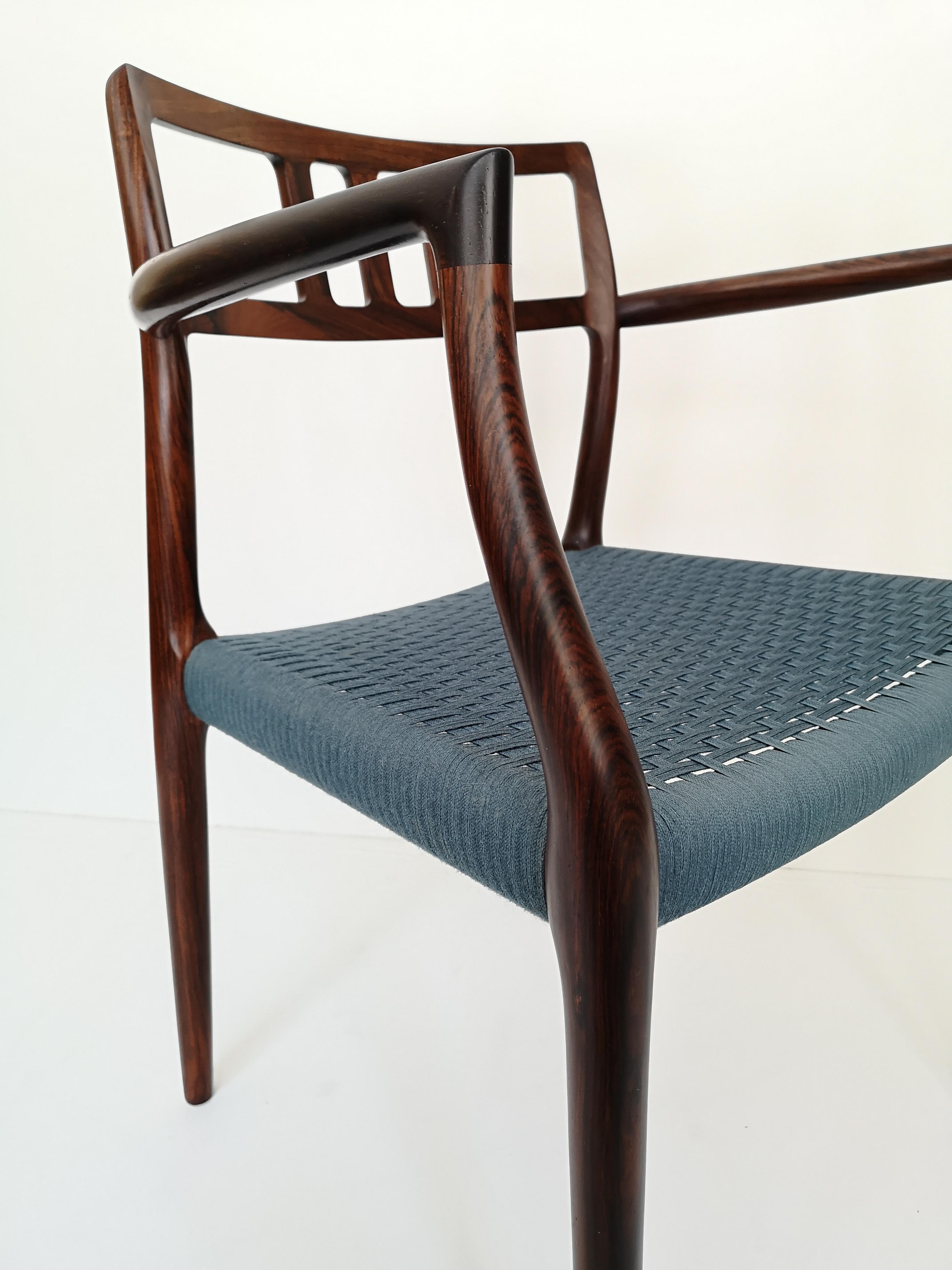 Model 64 armchair in highly figured Brazilian rosewood designed by Niels Moller. This example features rare, original, blue cording, in excellent condition. The finish is also original, and in very fine condition. Marked with Danish control button