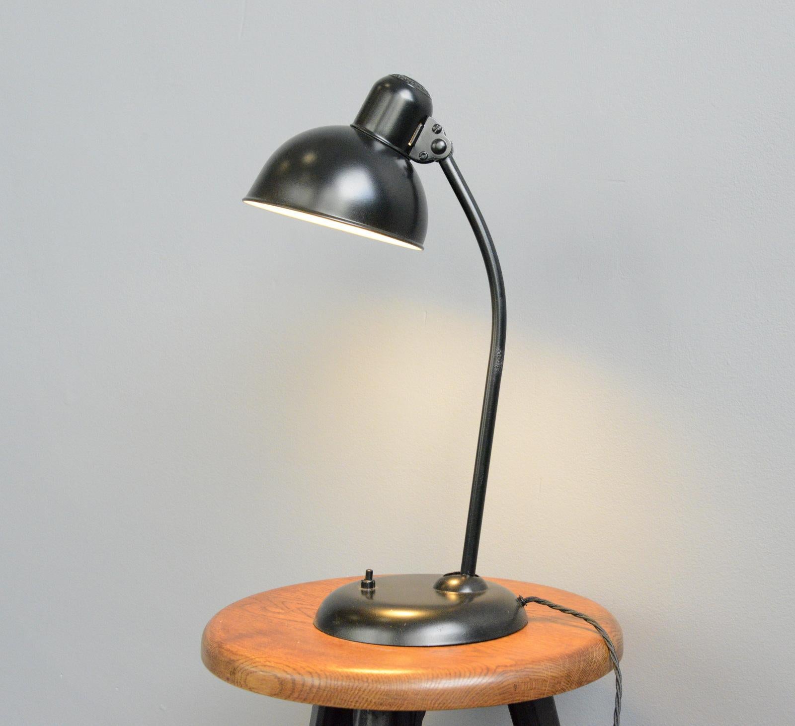 Model 6556 table lamp by Kaiser Idell, circa 1930s.

- Steel shade with relief Kaiser Idell branding
- On/Off switch on the base
- Takes E27 fitting bulbs
- Adjustable arm and shade
- Designed by Christian Dell
- Model 6556 Kaiser Idell
-