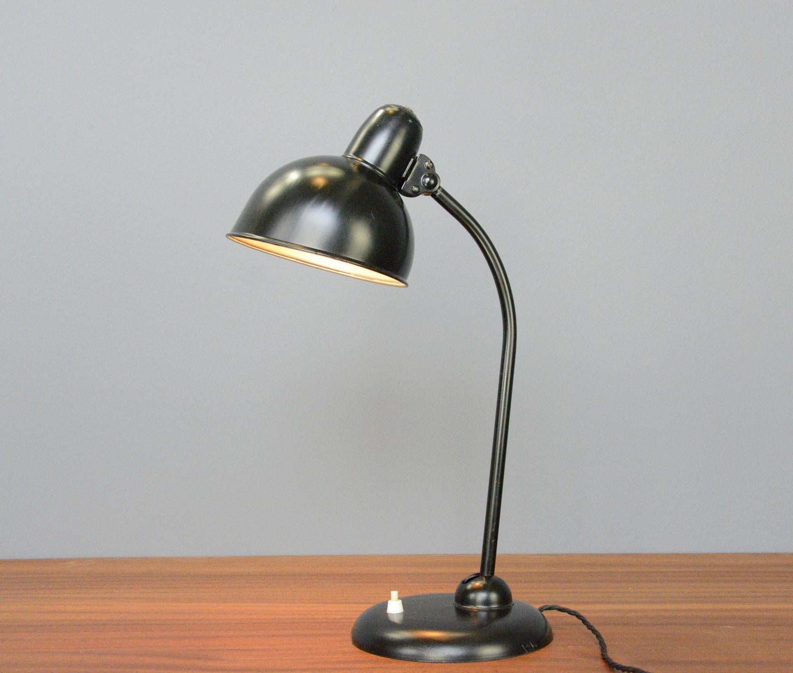 Model 6556 table lamp by Kaiser Idell Circa 1930s.

- Steel shade with relief Kaiser Idell branding
- On/Off switch on the base
- Takes E27 fitting bulbs
- Adjustable arm and shade
- Designed by Christian Dell
- Model 6556 Kaiser Idell
-