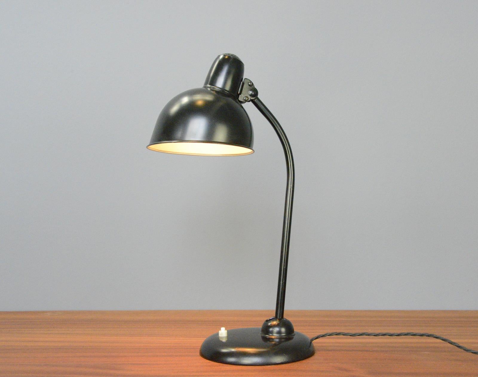 Model 6556 Table Lamp by Kaiser Idell Circa 1930s

- Steel shade with relief Kaiser Idell branding
- On/Off switch on the base
- Takes E27 fitting bulbs
- Adjustable arm and shade
- Designed by Christian Dell
- Model 6556 Kaiser Idell
-