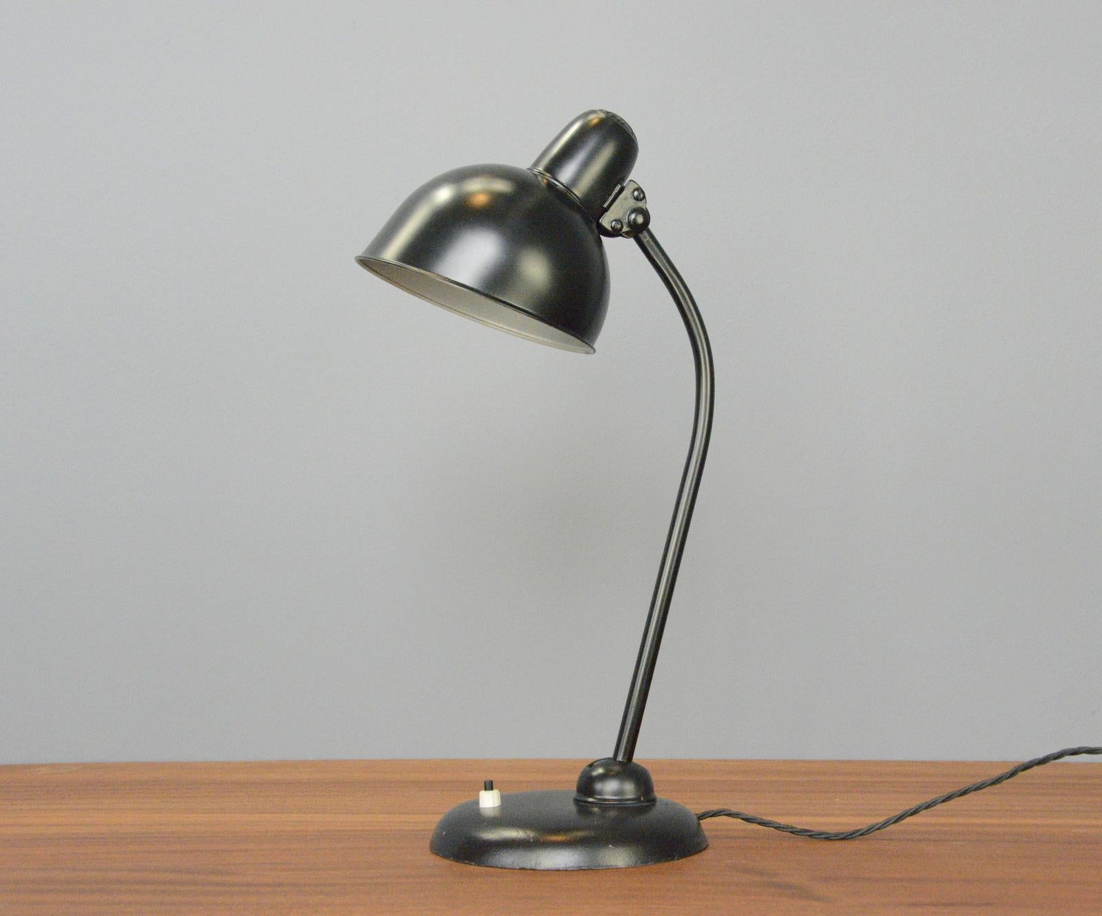 Model 6556 table lamp by Kaiser Idell Circa 1930s

- Steel shade with relief Kaiser Idell branding
- On/Off switch on the base
- Takes E27 fitting bulbs
- Adjustable arm and shade
- Designed by Christian Dell
- Model 6556 Kaiser Idell
-