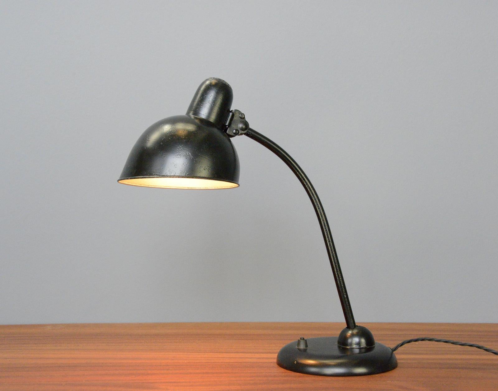 Model 6556 table lamp by Kaiser Jdell Circa 1930s

- Steel shade with relief Kaiser Jdell branding
- On/Off switch on the base
- Takes E27 fitting bulbs
- Adjustable arm and shade
- Designed by Christian Dell
- Model 6556 Kaiser Idell
-