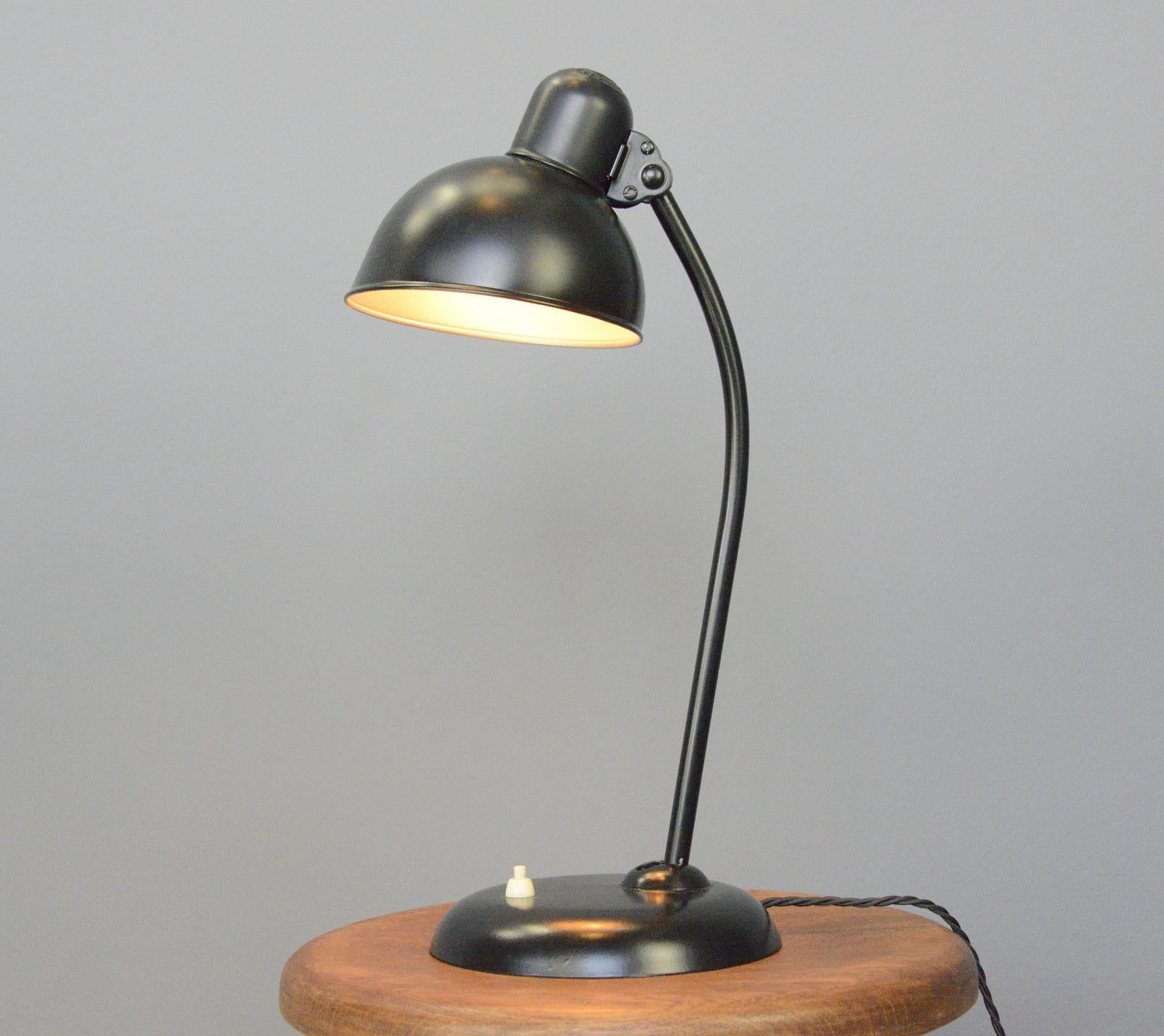 Model 6556 table lamps by Kaiser Idell Circa 1930s.

- Steel shade with relief Kaiser Idell branding
- On/Off switch on the base
- Takes E27 fitting bulbs
- Adjustable arm and shade
- Designed by Christian Dell
- Model 6556 Kaiser Idell
-