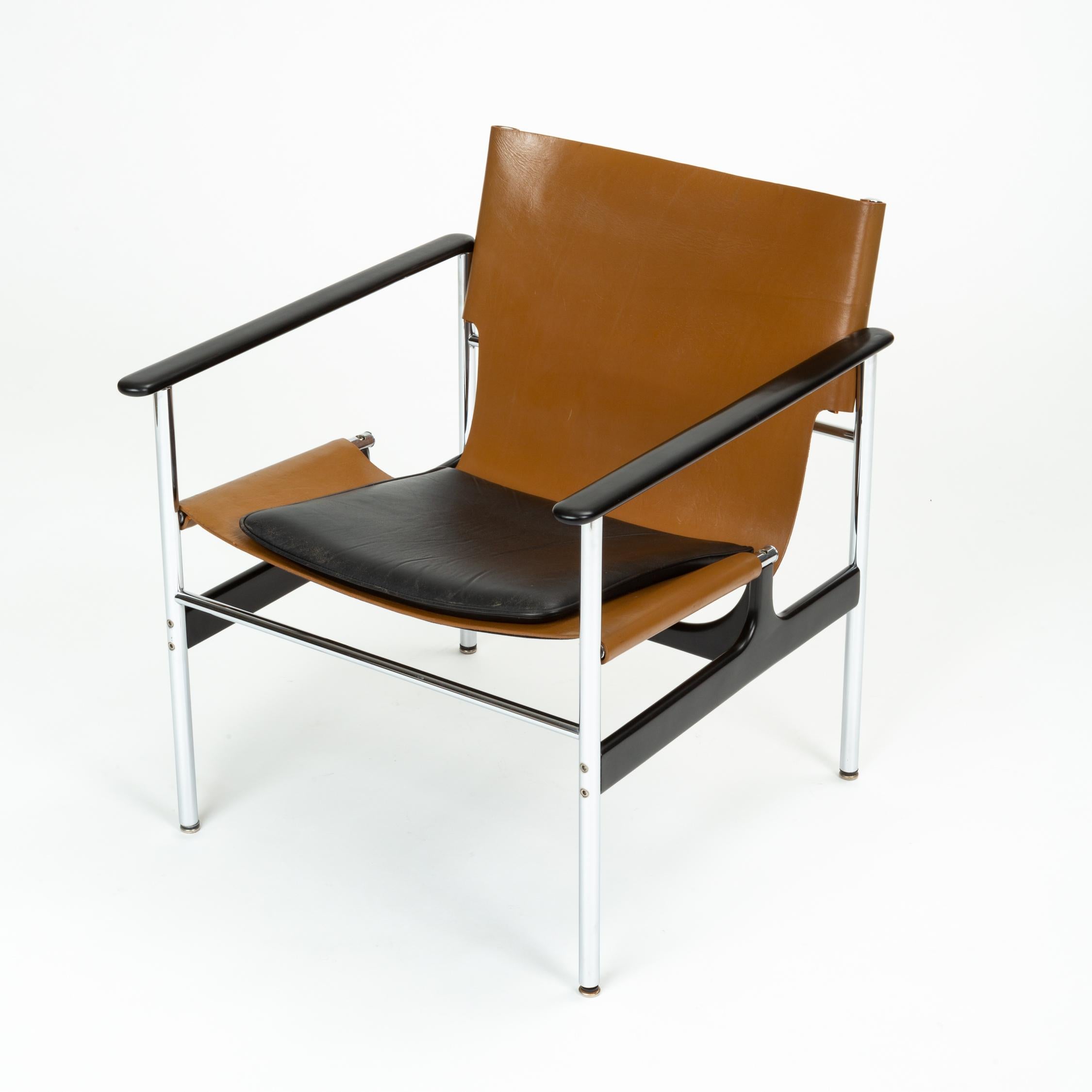 A sleek model 657 sling chairs designed in 1960 by Charles Pollock for Knoll. The chair was originally produced from 1964-1979 and features a steel structure with cast aluminum stretchers and rounded armrests. A sling of thick tan leather is bolted