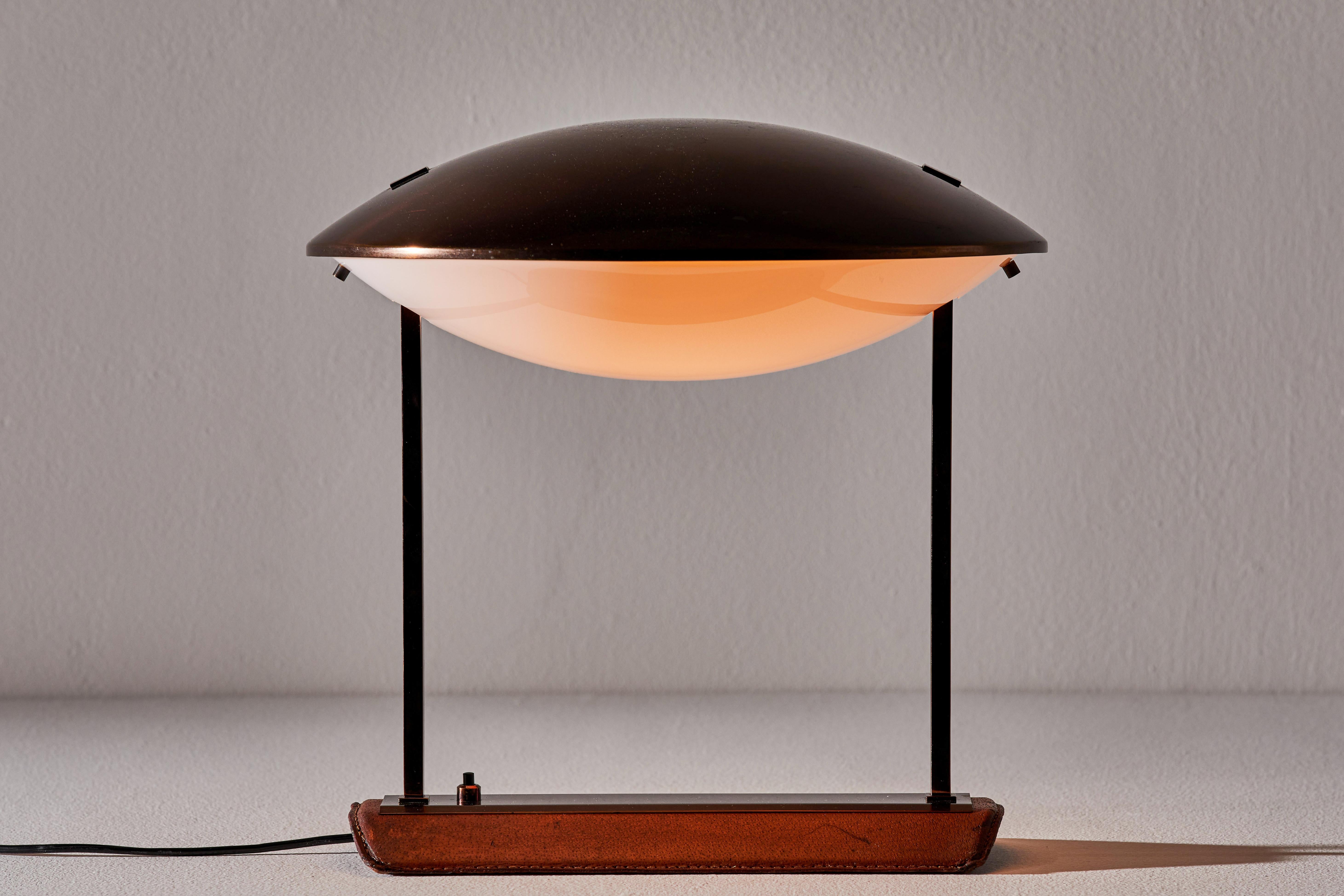 Model 8050 table lamp by Stilnovo. Manufactured in Italy, circa 1950s. Leather and copper base with copper and white acrylic shade. Original cord. We recommend one E26 60w maximum bulb. Bulbs provided as a one time courtesy. Literature: 1000 Lights,