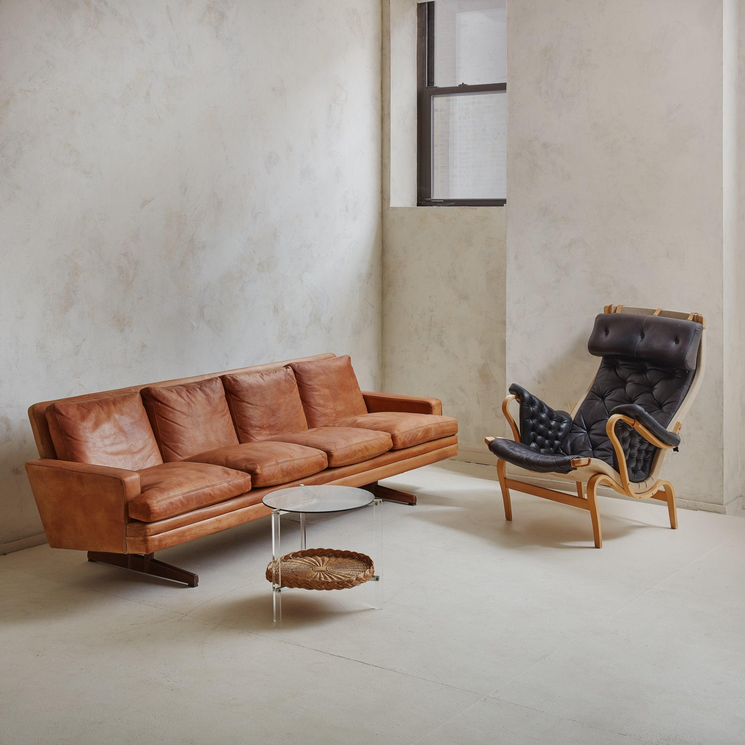 A Scandinavian Modern 'Model 807' cognac leather sofa designed by Frederik Kayser for Vatne Møbler in the 1960s. This four-seat sofa rests on two solid rosewood shaker legs and features original cognac leather upholstery with a beautiful, natural