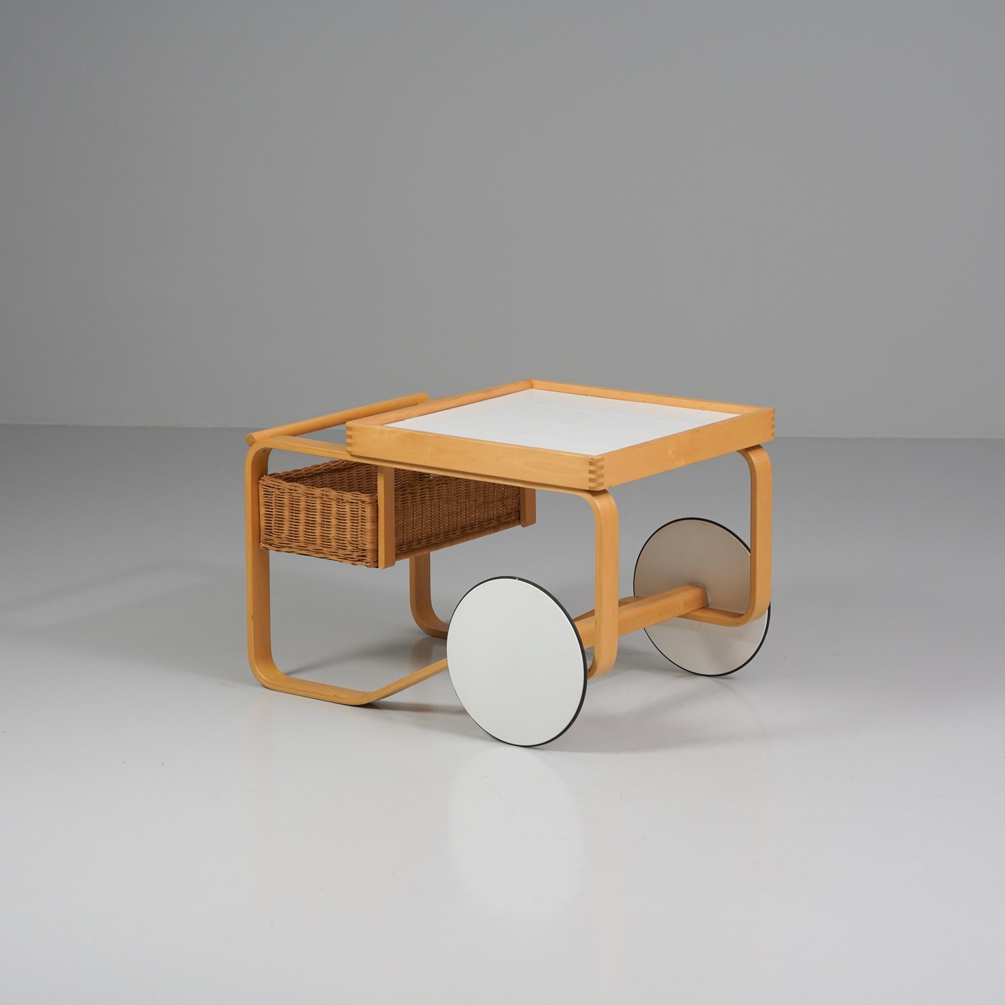Model 900 tea cart, designed by Alvar Aalto, manufactured by Artek, 1980/1990s. Birch frame, ceramic tiles, rattan basket. Good vintage condition, patina consistent with age and use. 

Alvar Aalto (1898-1976) is probably the most famous Finnish
