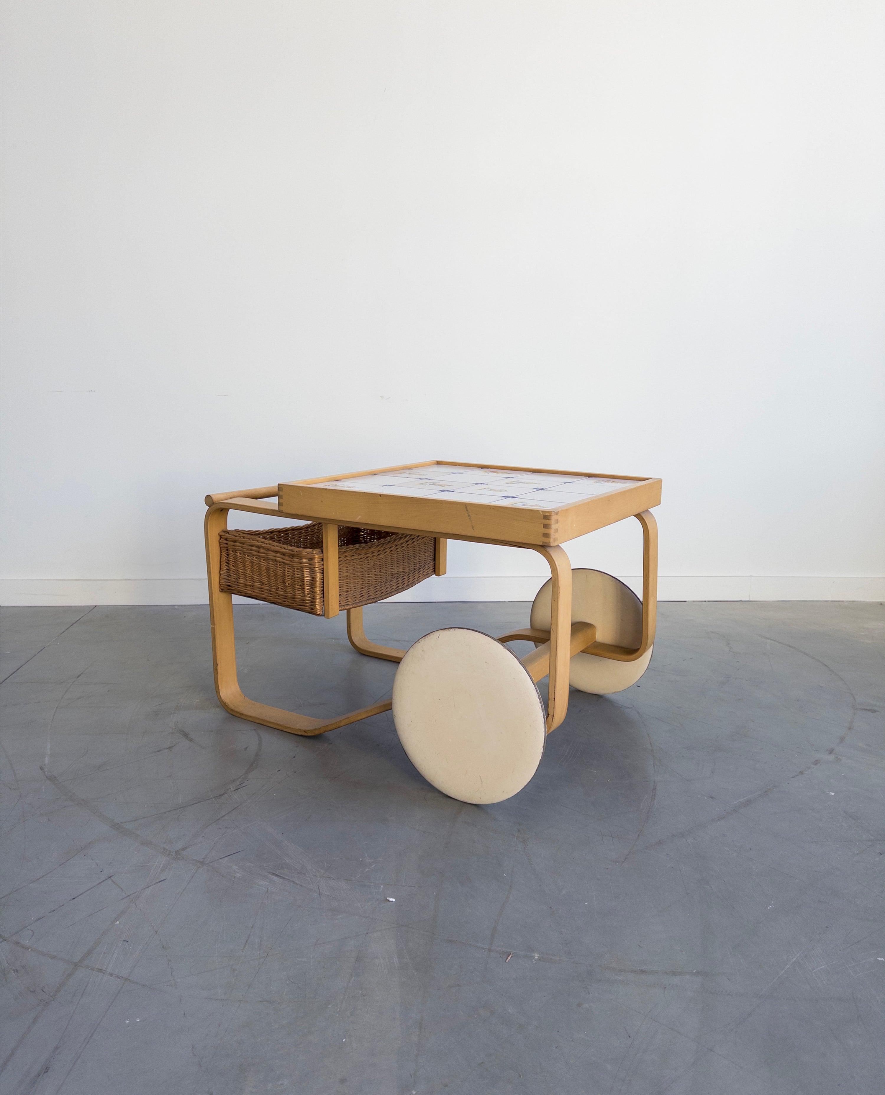 The Model 900 by Alvar Aalto was first exhibited at the World Exhibition in Paris in 1937. Features hand-painted ceramic tiles and a rattan basket.

The tea trolley was inspired by British tea culture, which Aino and Alvar Aalto had become