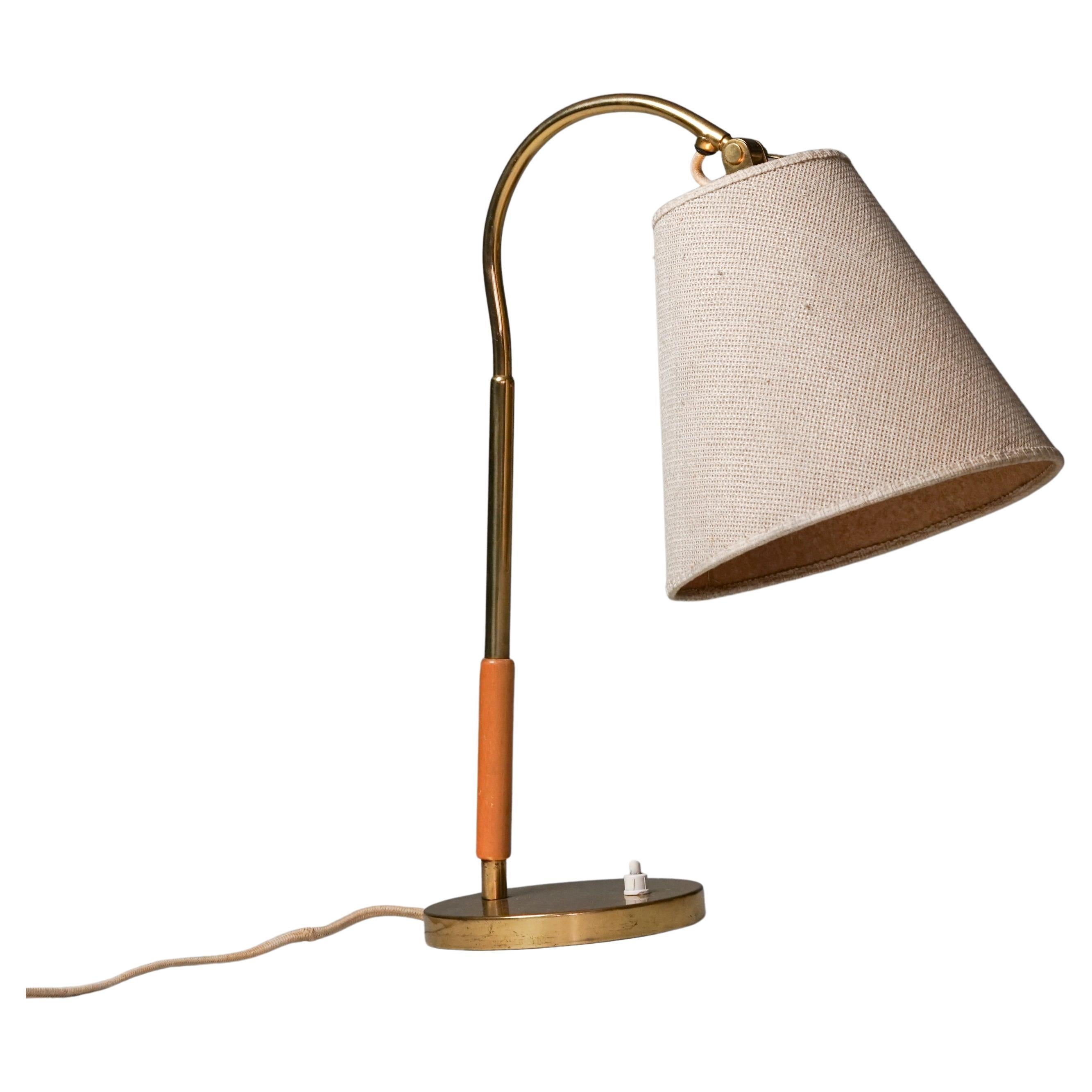 Model 9201 table lamp, designed by Paavo Tynell, manufactured by Taito Oy, 1940/1950s. Brass frame with original fabric lampshade and wood detail. Good vintage condition, minor patina consistent with age and use. Timeless Scandinavian Modern