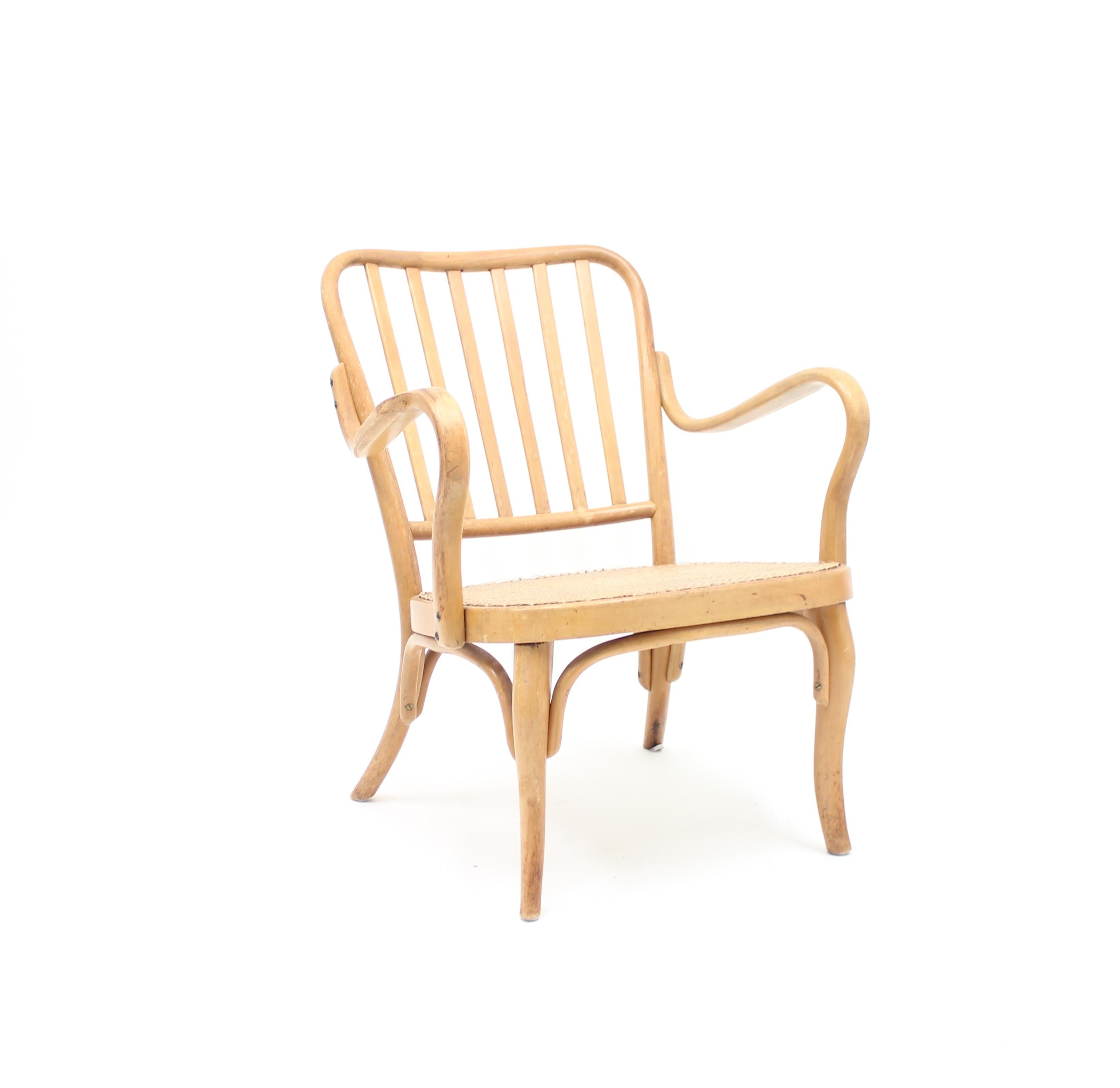 Bentwood lounge chair model A 752 designed by Josef Frank for Thonet in the 1930s. Seat with rattan upholstery. Wooden parts with patina. Later upholstered rattan in good condition.