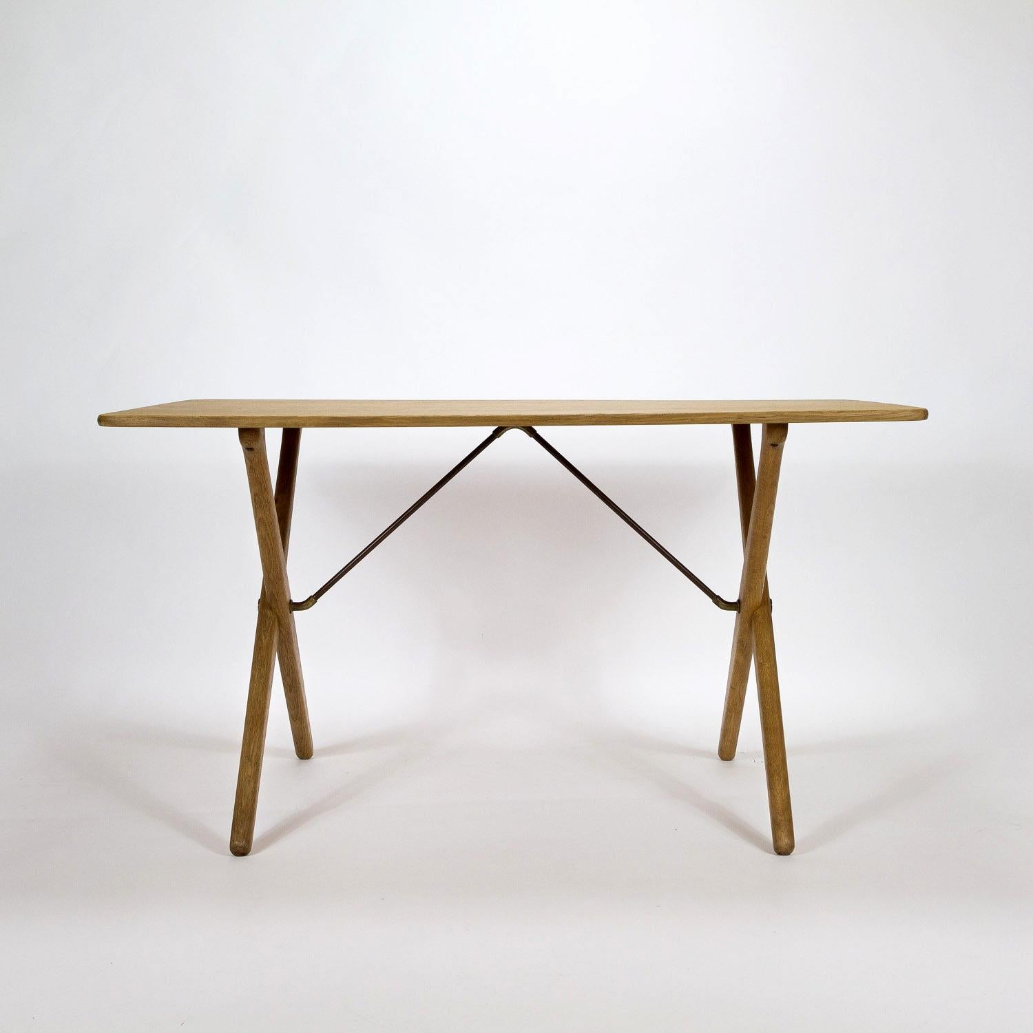 A fully restored midcentury cross-leg oak Model AT308 side table designed by Hans Wegner and made by Andreas Tuck in Denmark, 1950s. Brass and metal struts. New oak veneer on the table top and underside, we have kept the original designer’s and