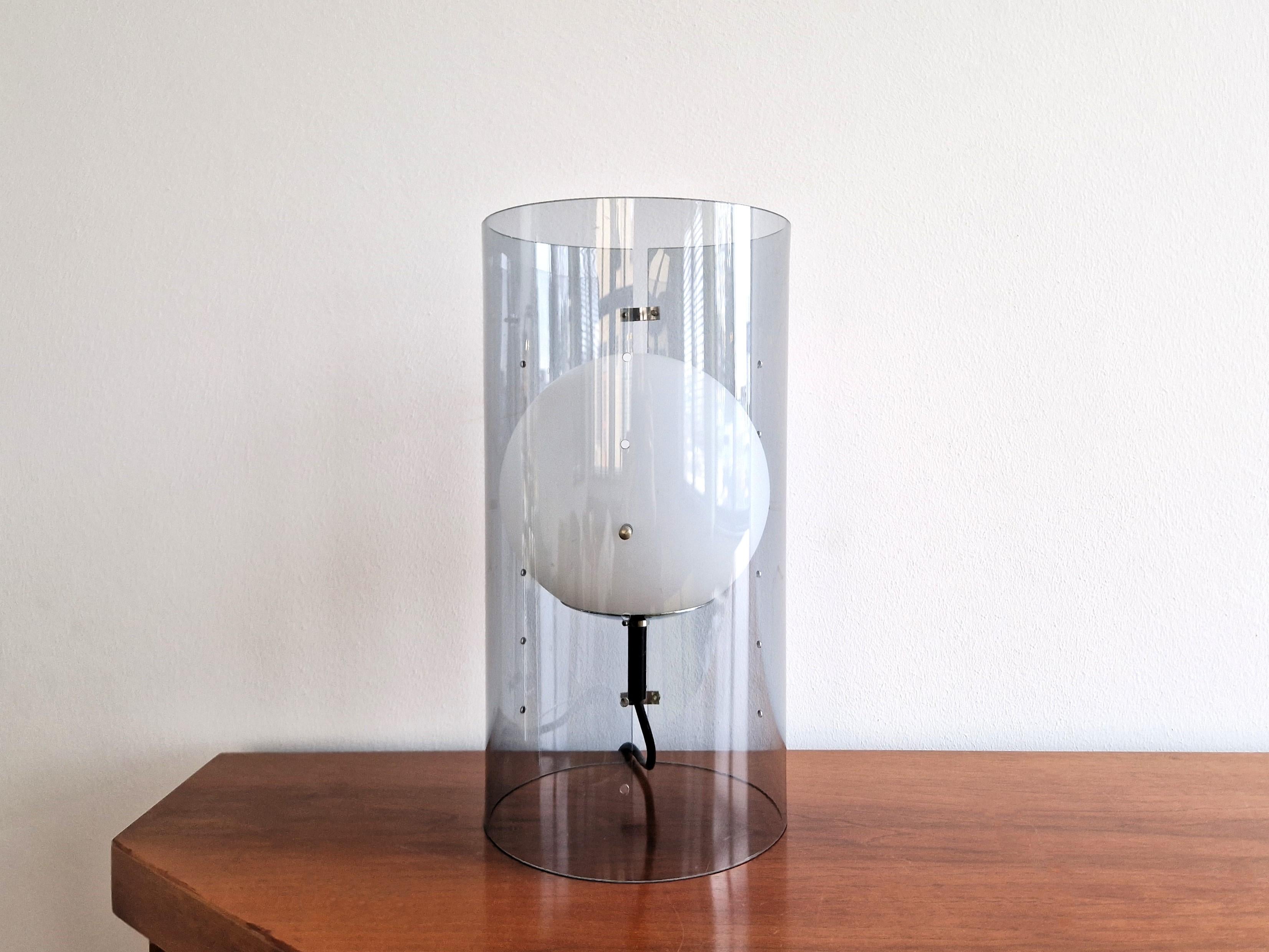 This lovely and rare table lamp was designed for Raak Amsterdam in te 1960's. It consists out of a light grey acrylic cylindrical tube with an opaline glass globe inside. The globe is adjustable in height by replacing the metal pins at the small