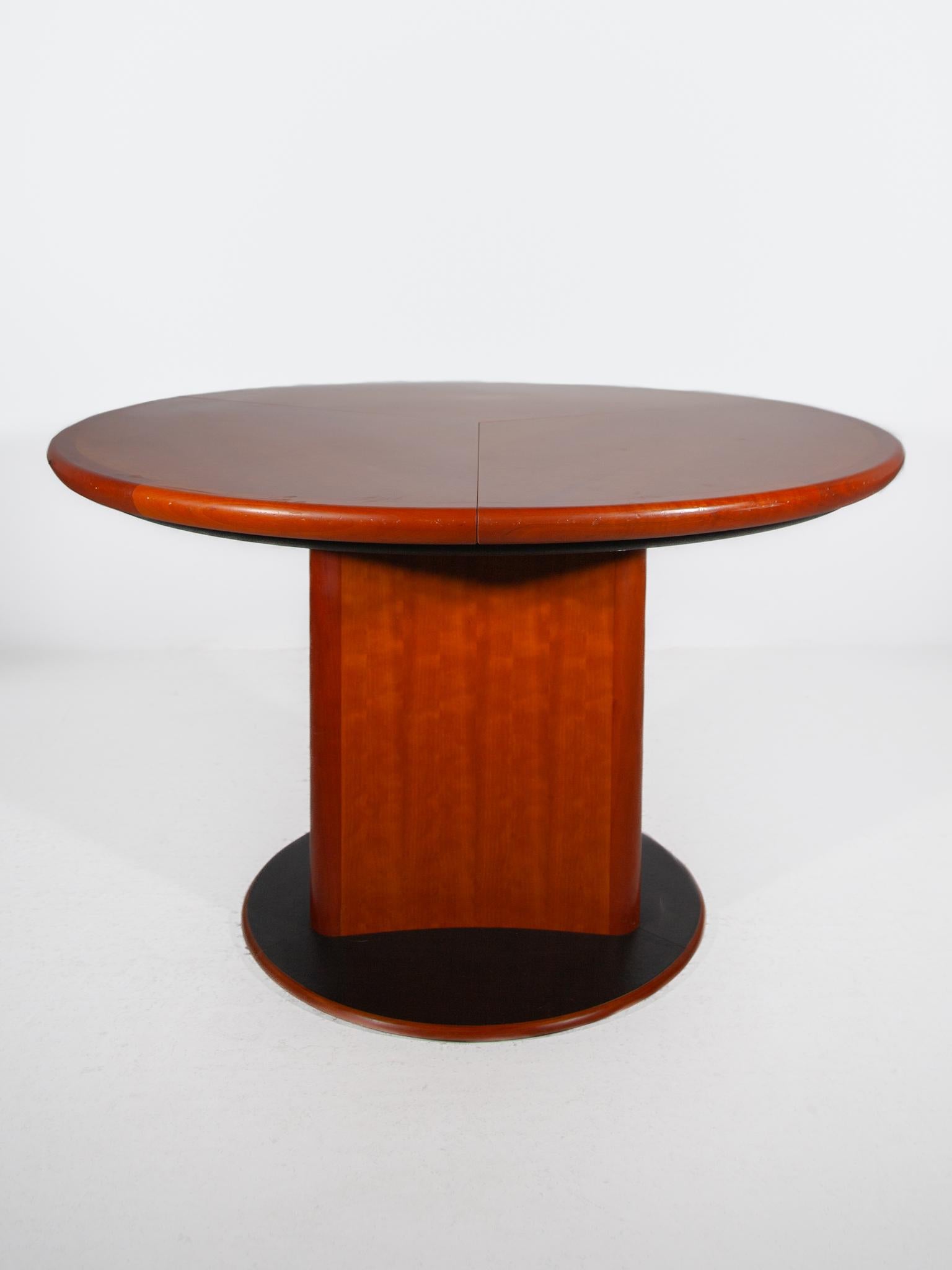 Beautiful Round Dining table designed by Skovby in 1988 Model dc06, Constructed from teak wood, the table features a curved triangular pedestal base and a round tabletop. The three leaves of the table pull outwards from a turntable mechanism to