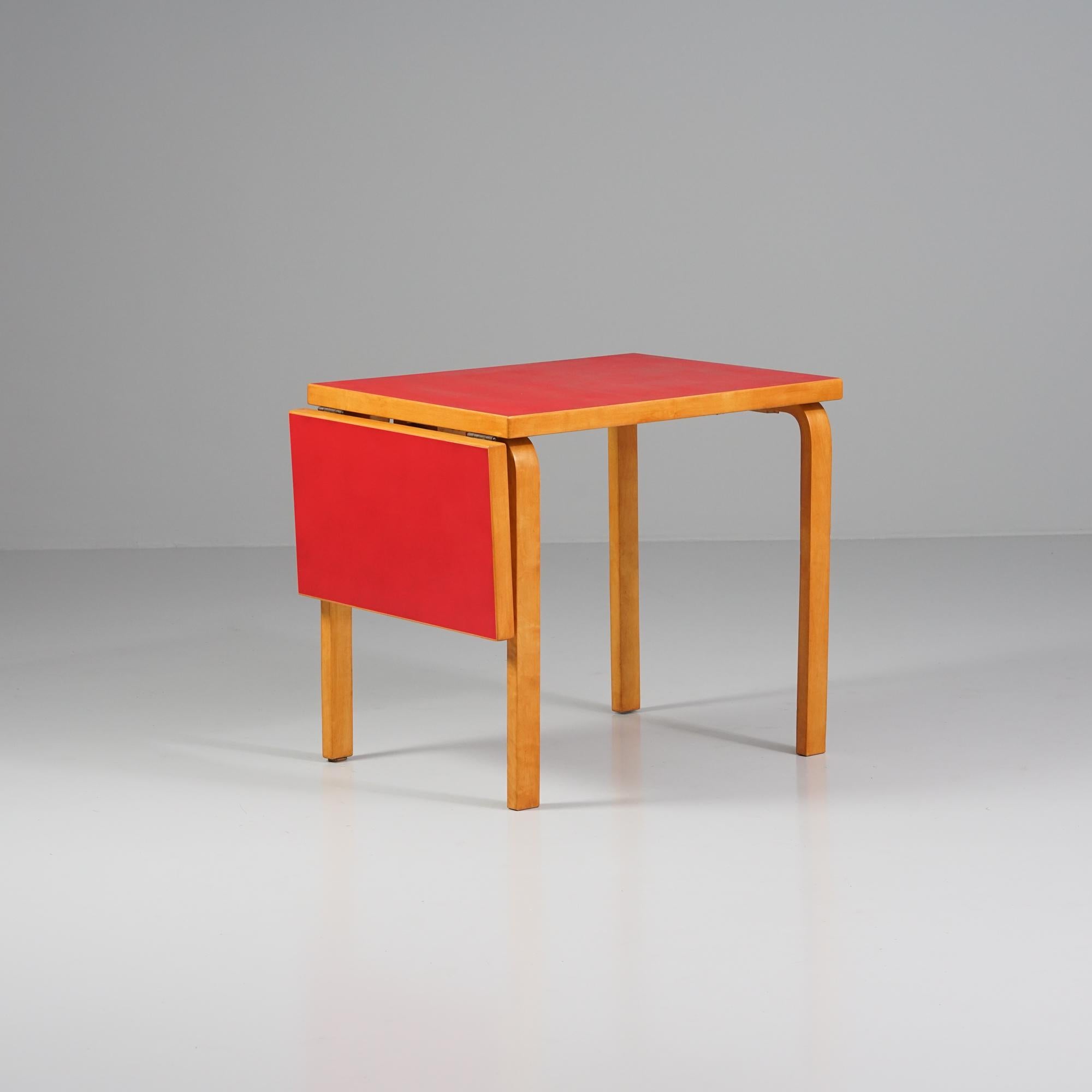 Tavolo a ribalta modello DL82, disegnato da Alvar Aalto, prodotto da Oy Huonekalu- ja Rakennustytehdas Ab, anni 1950/960. Struttura in betulla, piano in linoleum rosso. Parti in betulla restaurate. Buone condizioni vintage, lieve patina coerente con