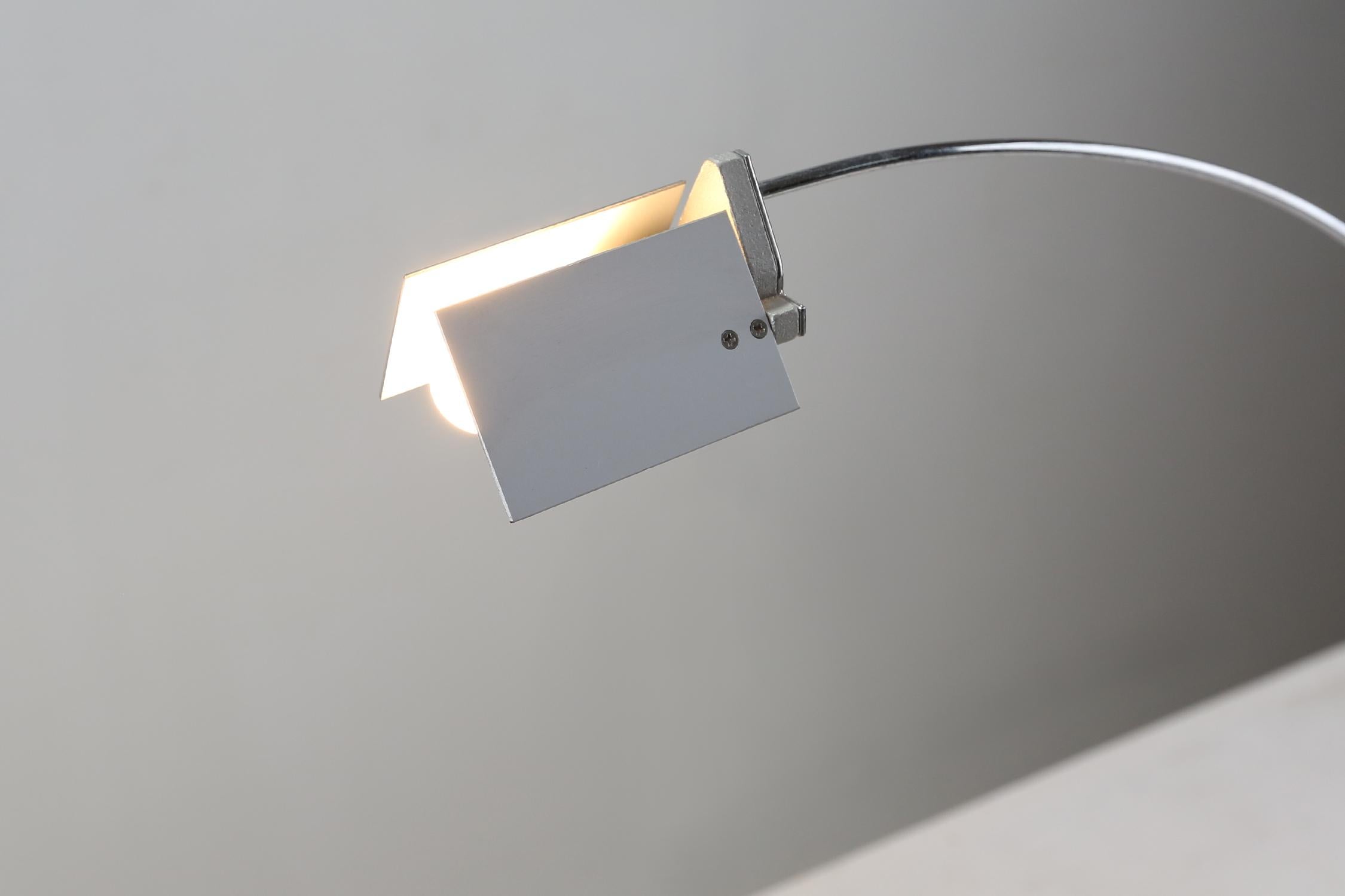 Low-voltage table lamp made in 1994 with electronic plug-in transformer and cable switch for dual light intensity. With a glass base in cut float glass and a chromed metal body with 360° horizontal rotation.