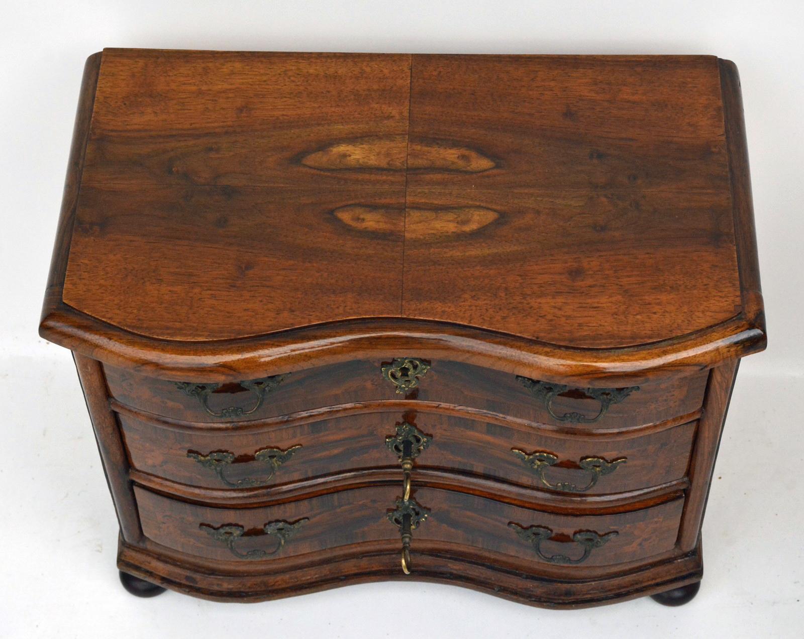 Model Furniture, Baroque dresser, 1750s. Made of walnut and other fine woods. A rare collector's item of high historical value. 

Pressed ball feet, double curved front with three drawers. Drawers and sides with fine ribbon and field marquetry. The